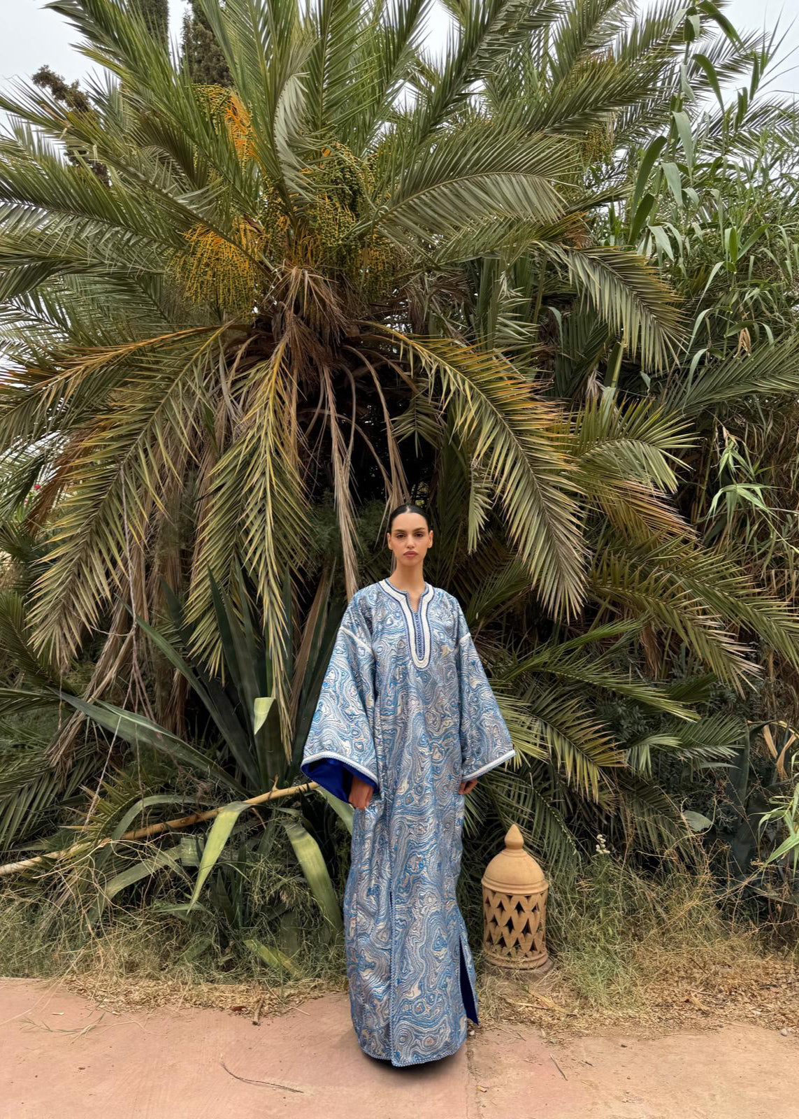Full-length view of a model wearing a modern blue brocade Kaftan