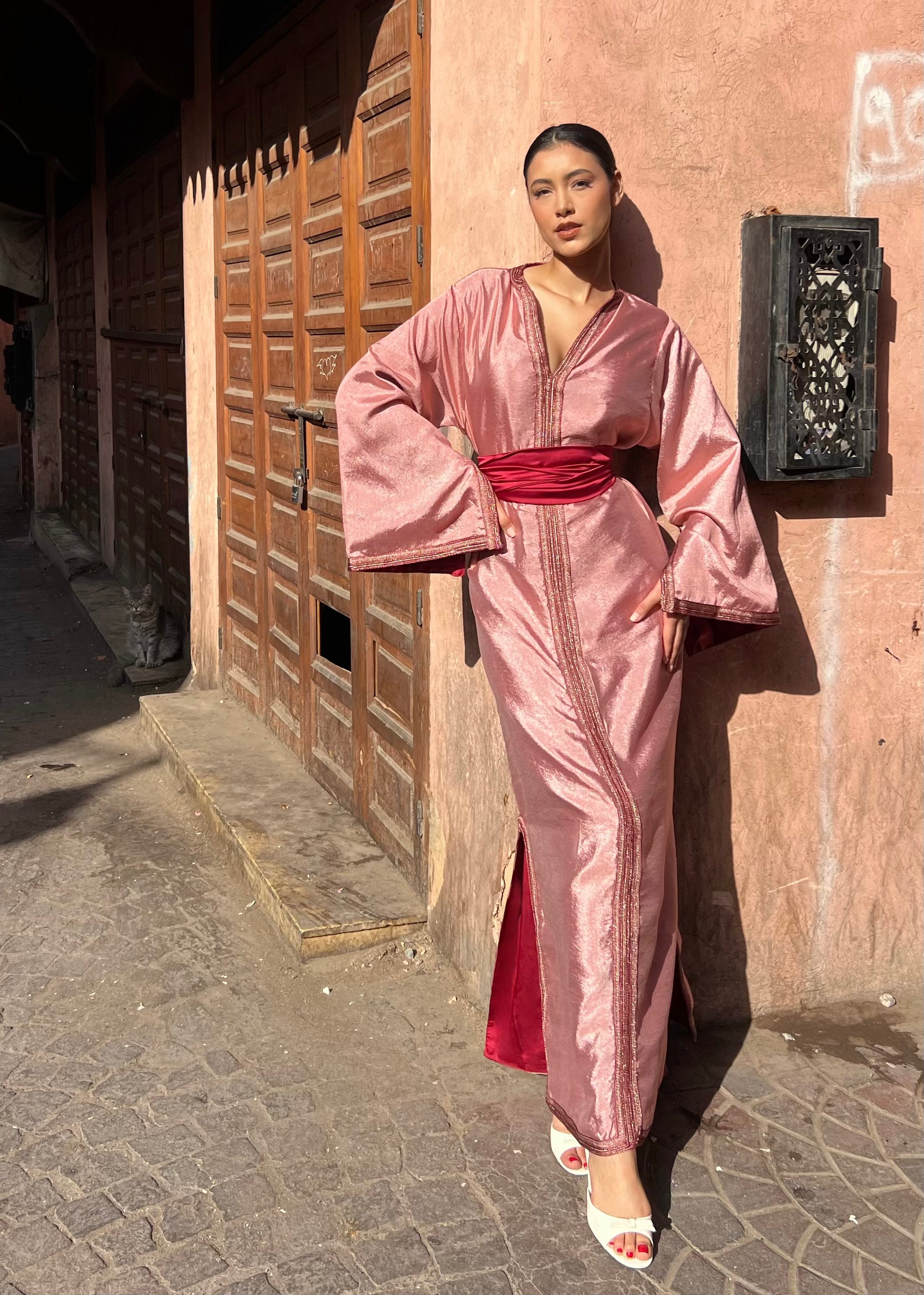 Modern Kaftan in draped pink satin in motion, fluid effect and luminous satin highlights