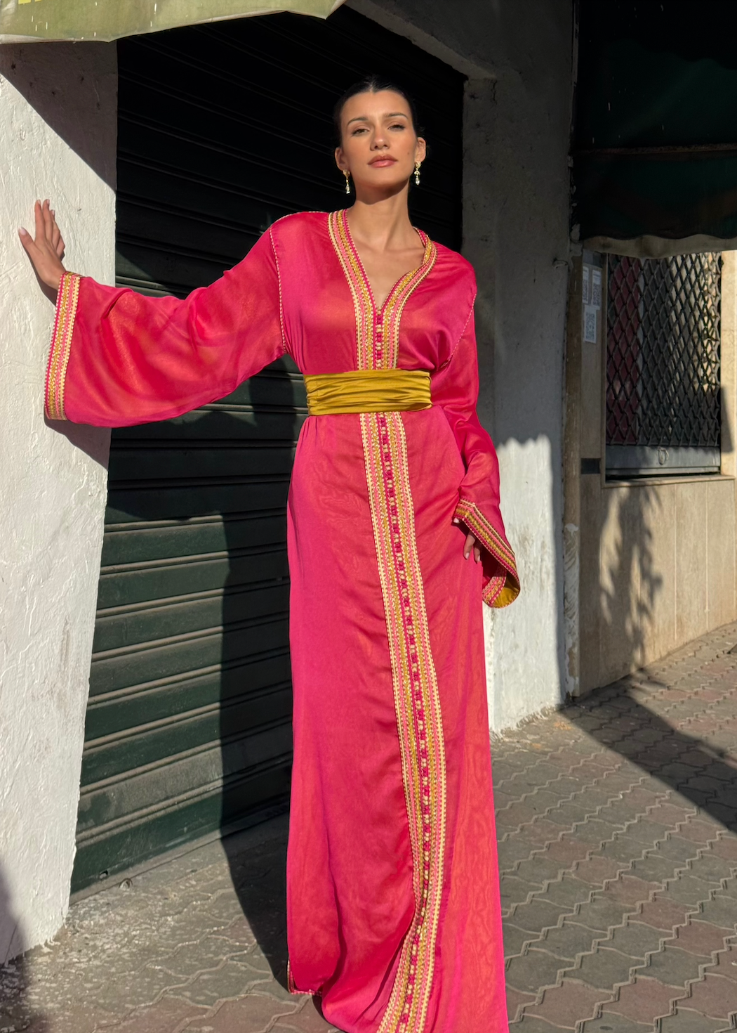 Kaftan in fuchsia-pink chiffon captured in motion, highlighting the airy lightness of the fabric and vibrant shades of pink.