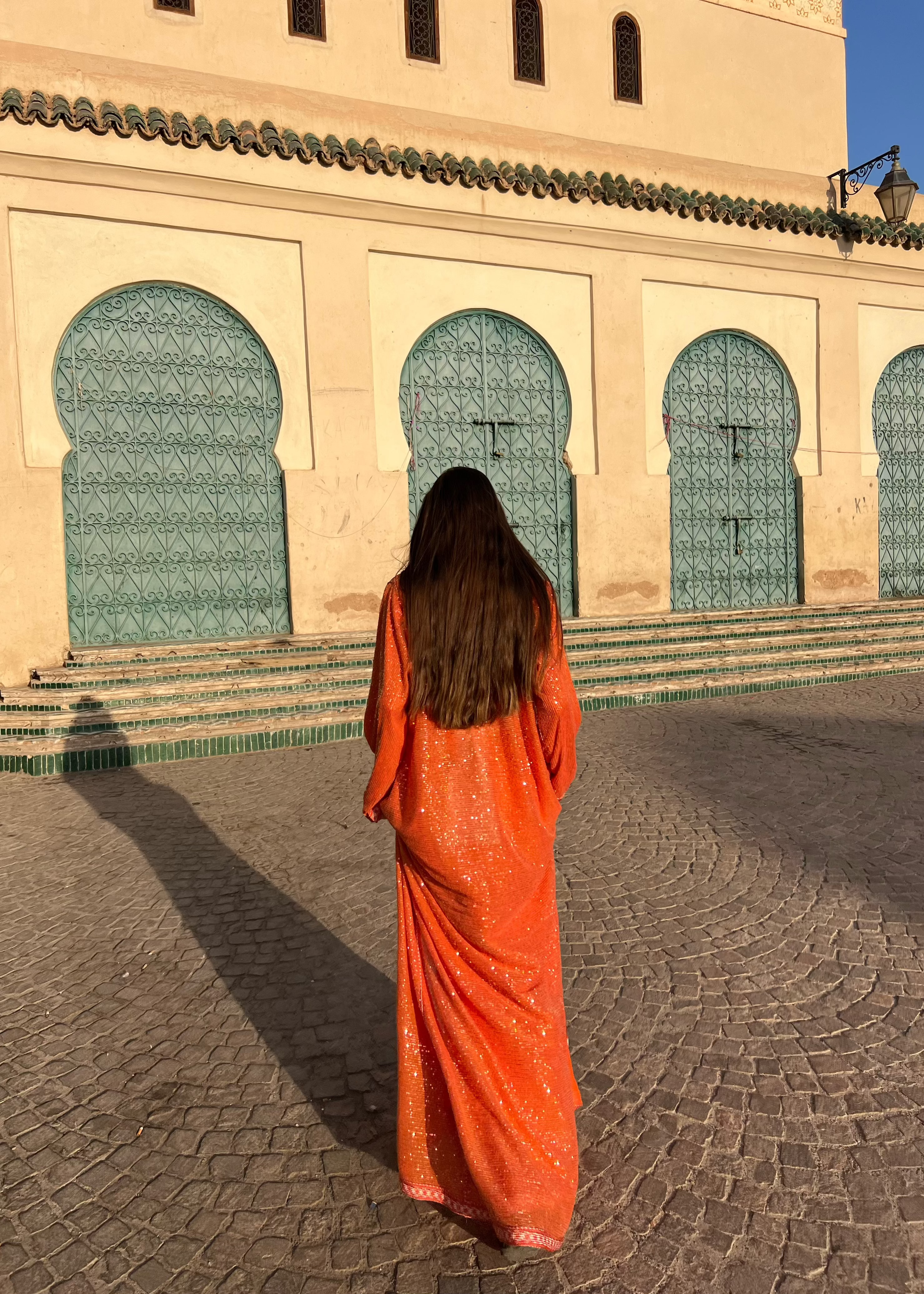 Back of the orange Kaftan in tulle adorned with pearls, fluid fall and matching belt