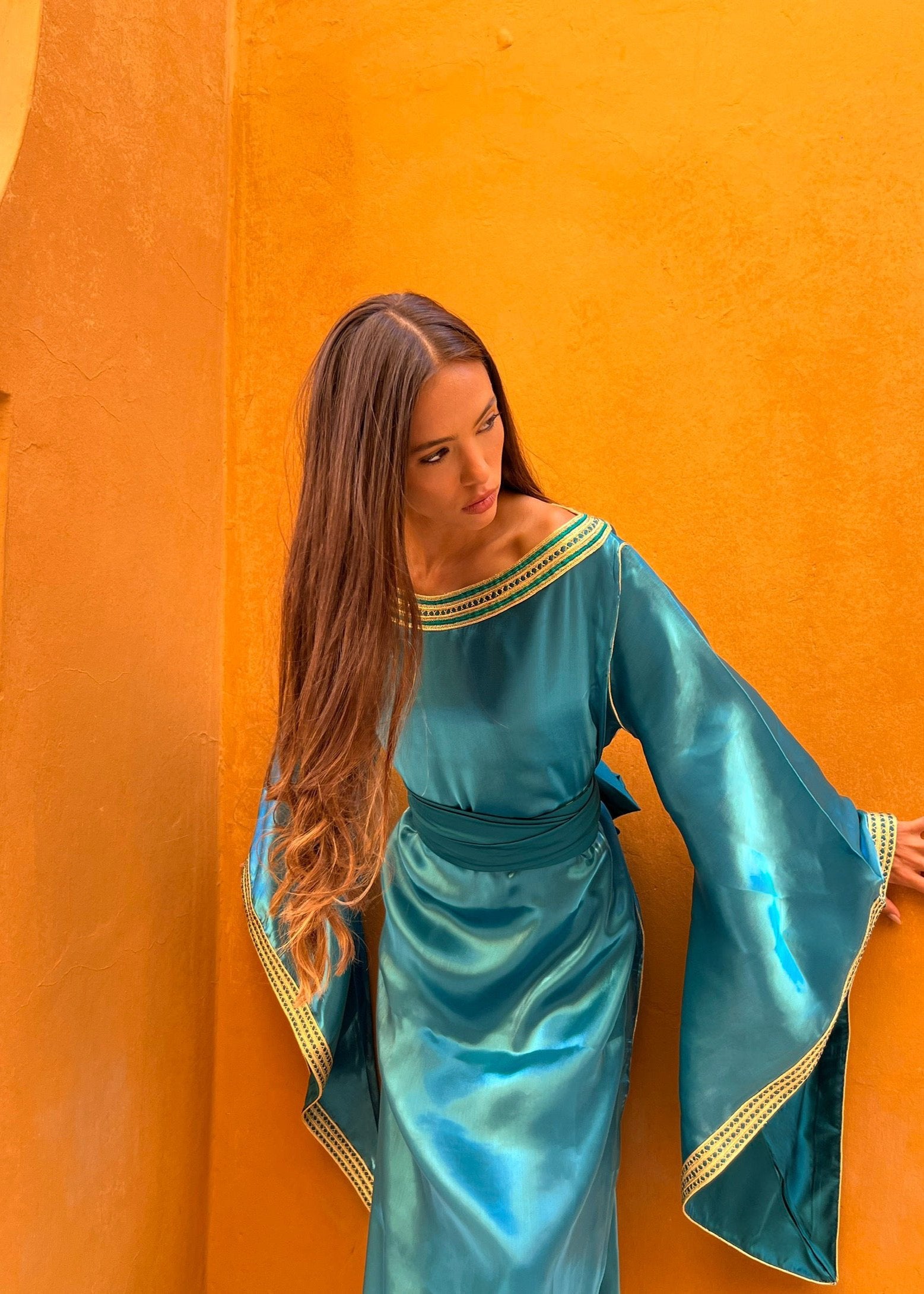 Sapphire blue organza Kaftan with flared sleeves captured in motion, highlighting the lightness of the fabric and the brilliance of the sapphire blue.
