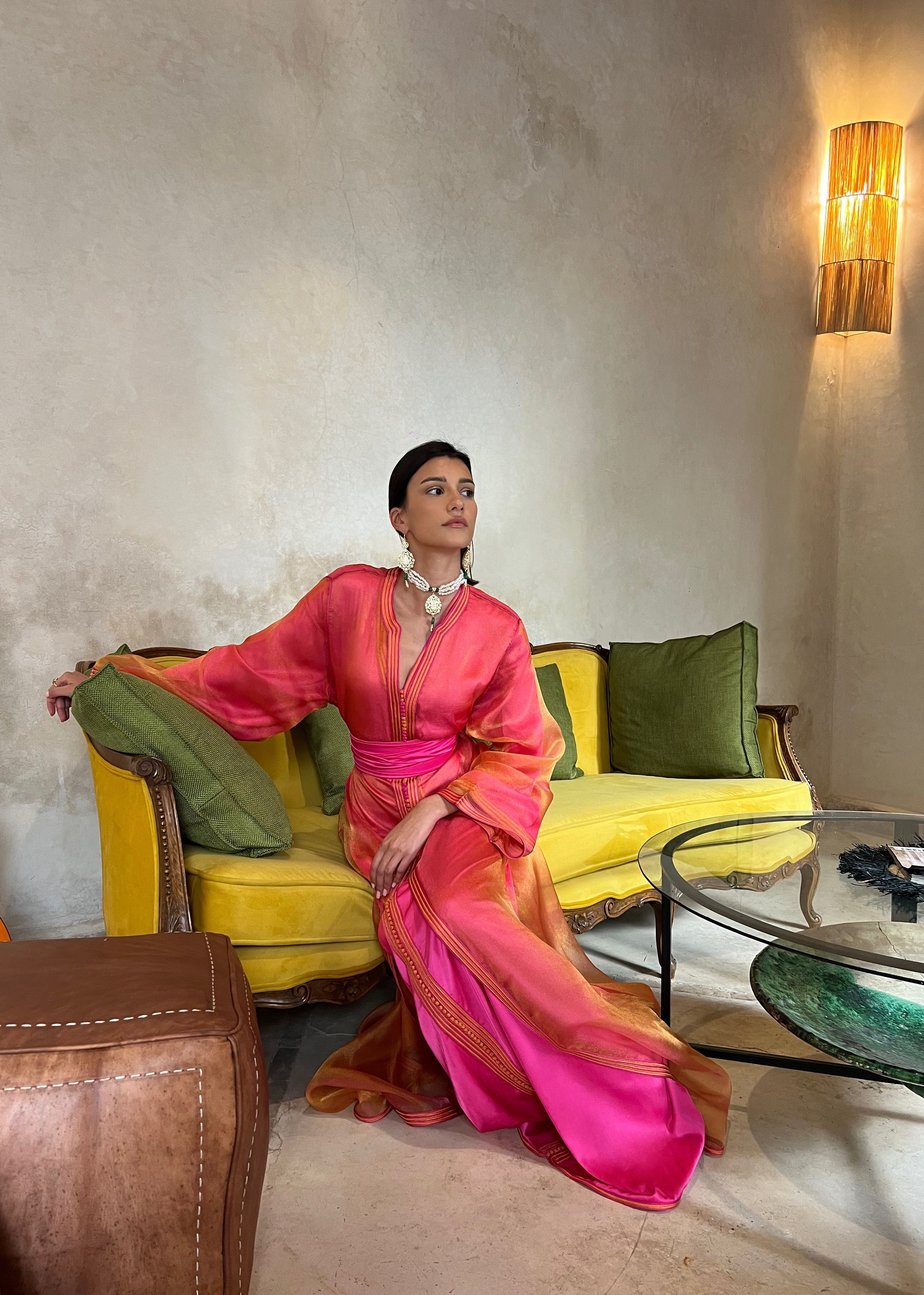 Kaftan in orange and pink organza captured in motion, highlighting the airy fluidity of the fabric and the richness of the colorful reflections.
