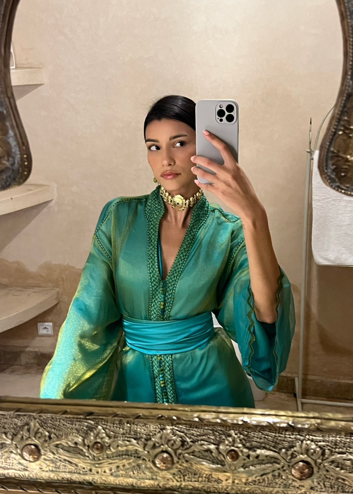 Kaftan in green and blue organza seen in profile, emphasizing the softness of the shades and the elegance of the drape.