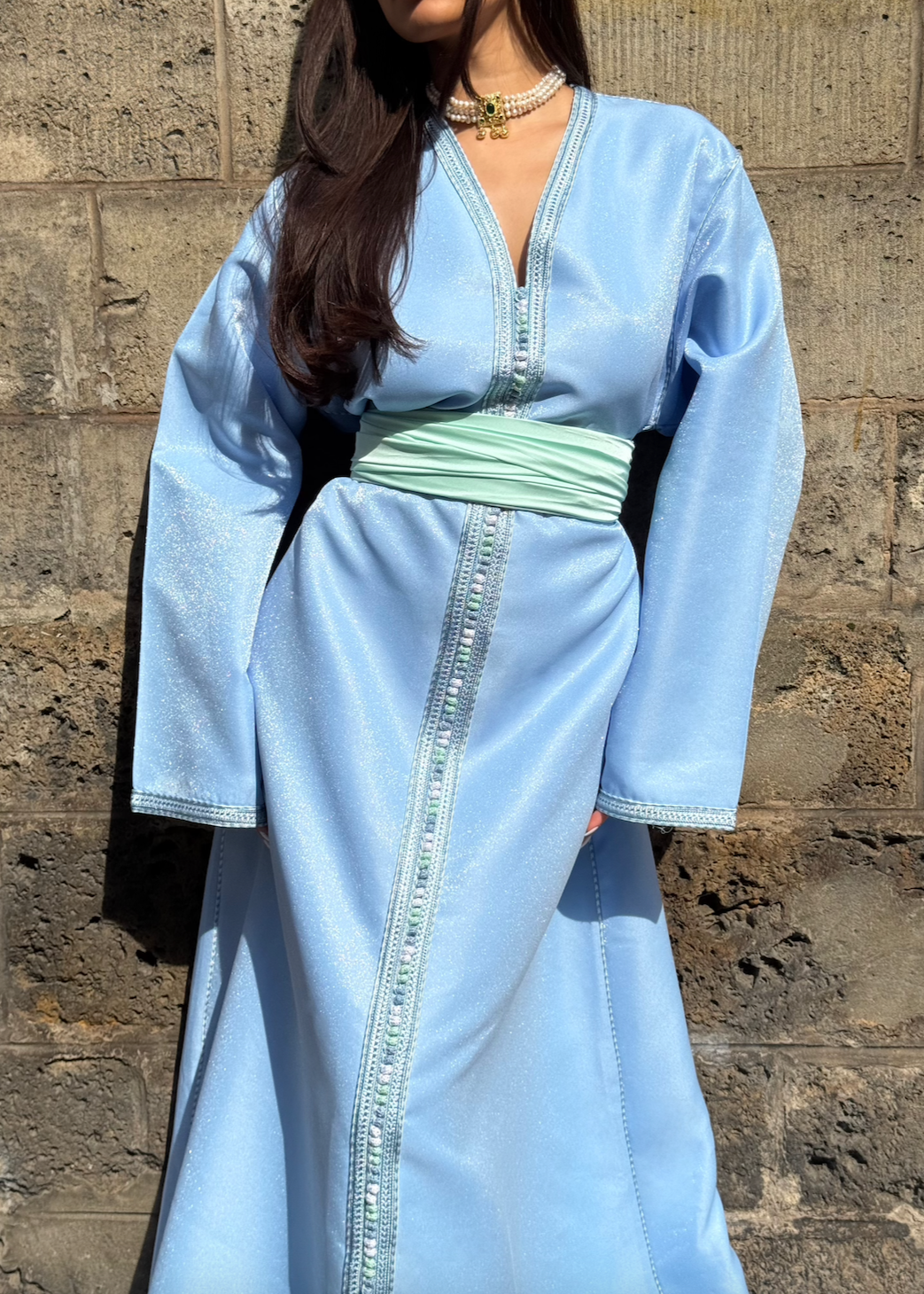 Blue satin Kaftan seen from the front, featuring an elegant cut and the sheen of the satin.