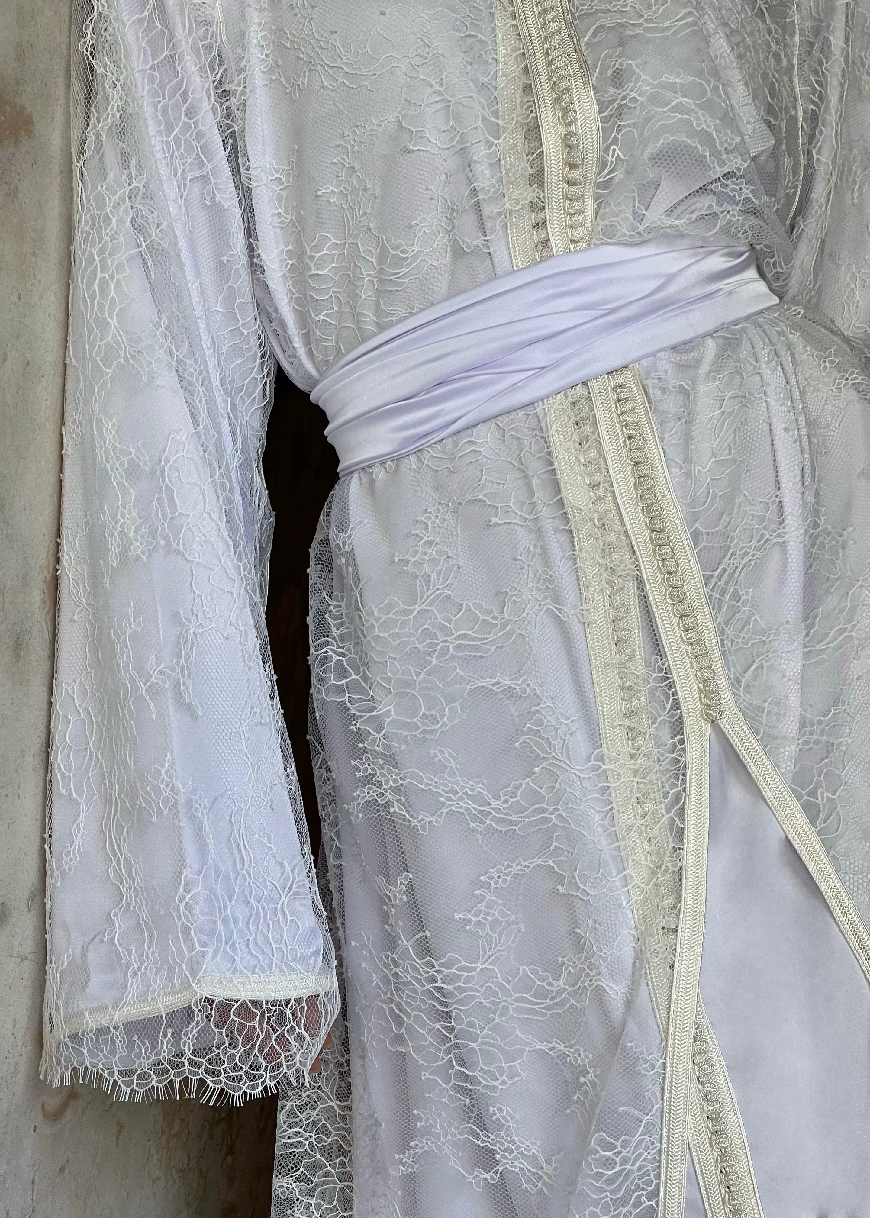 Detail of the bridal Kaftan in white Calais lace, delicate floral embroidery and haute couture finishes