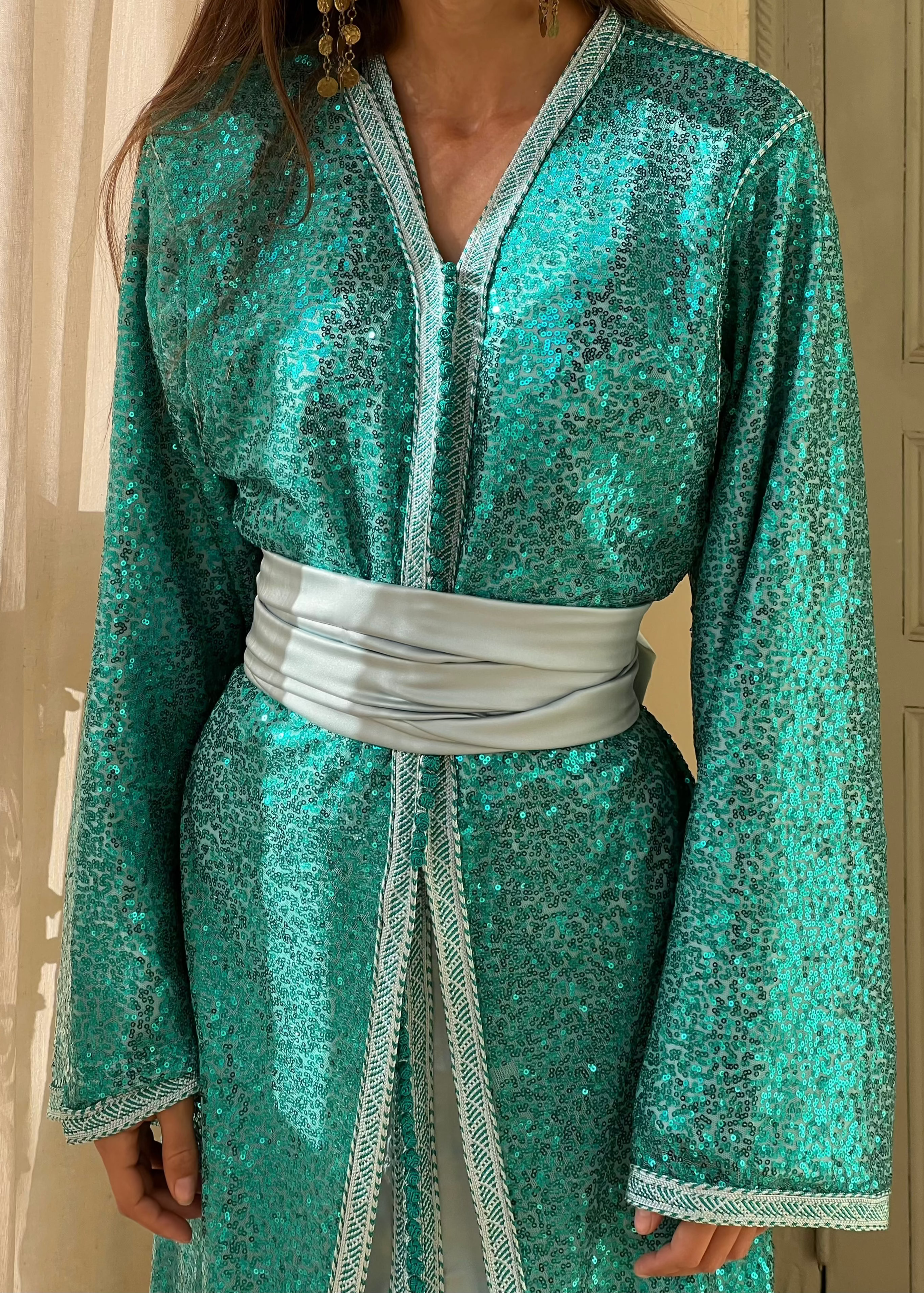 Detail of the turquoise Kaftan 's sequined tulle, soft silk lining and refined couture finishes