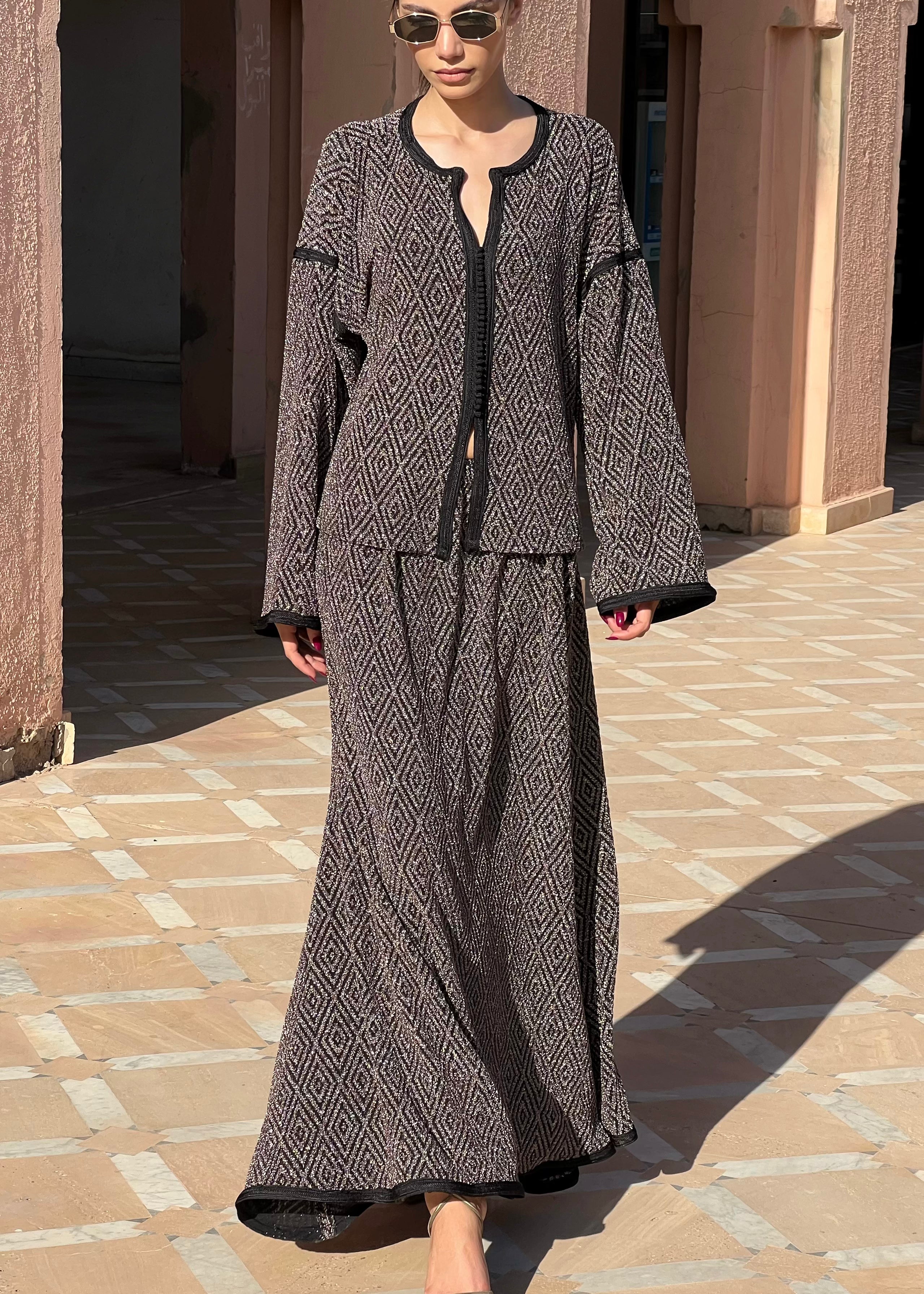 Long skirt and shirt ensemble in black and gold jacquard with sfifa, elegant cut and refined details, front view on mannequin