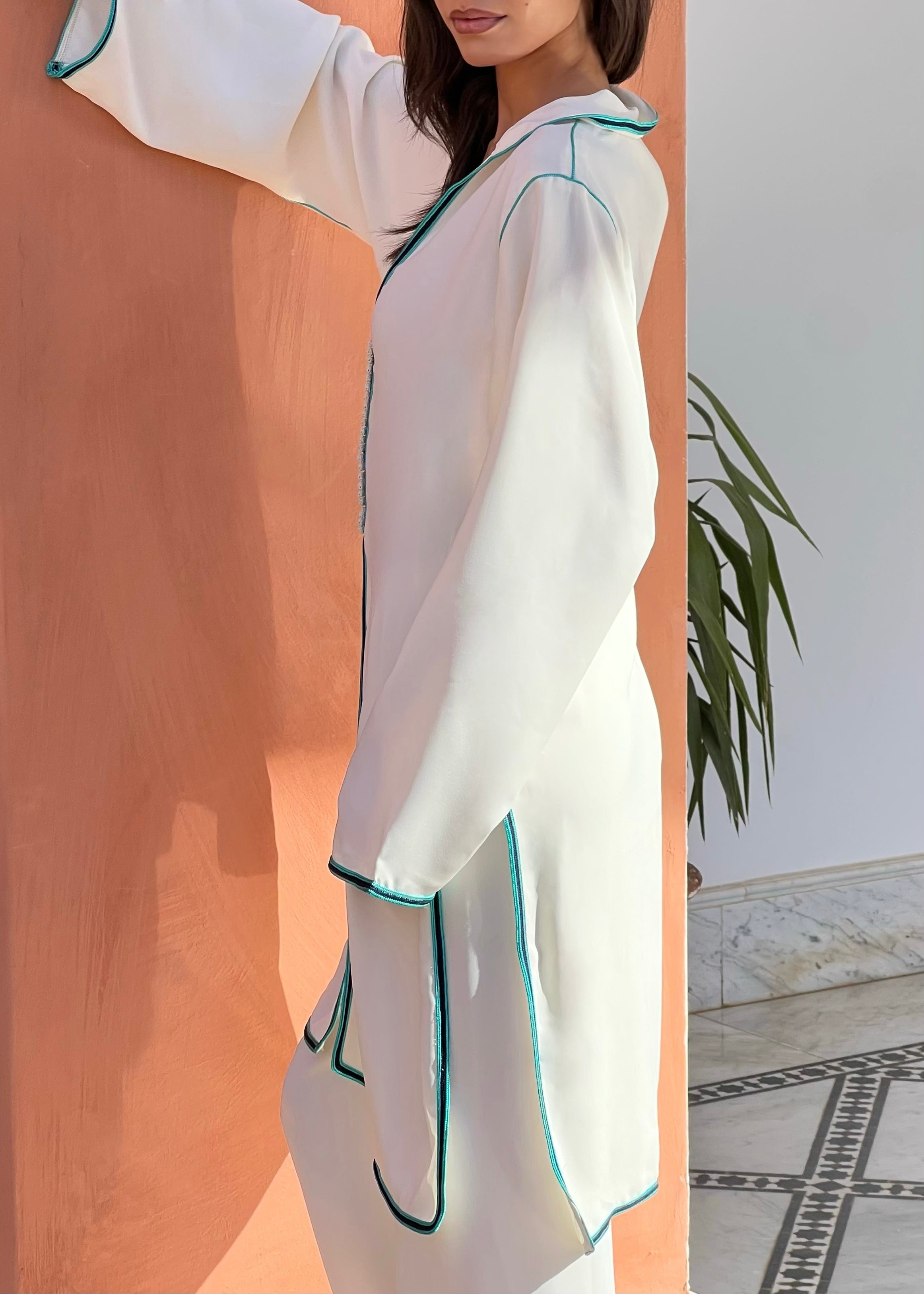 Profile of white silk crepe tunic with blue sfifa, elegant straight pants