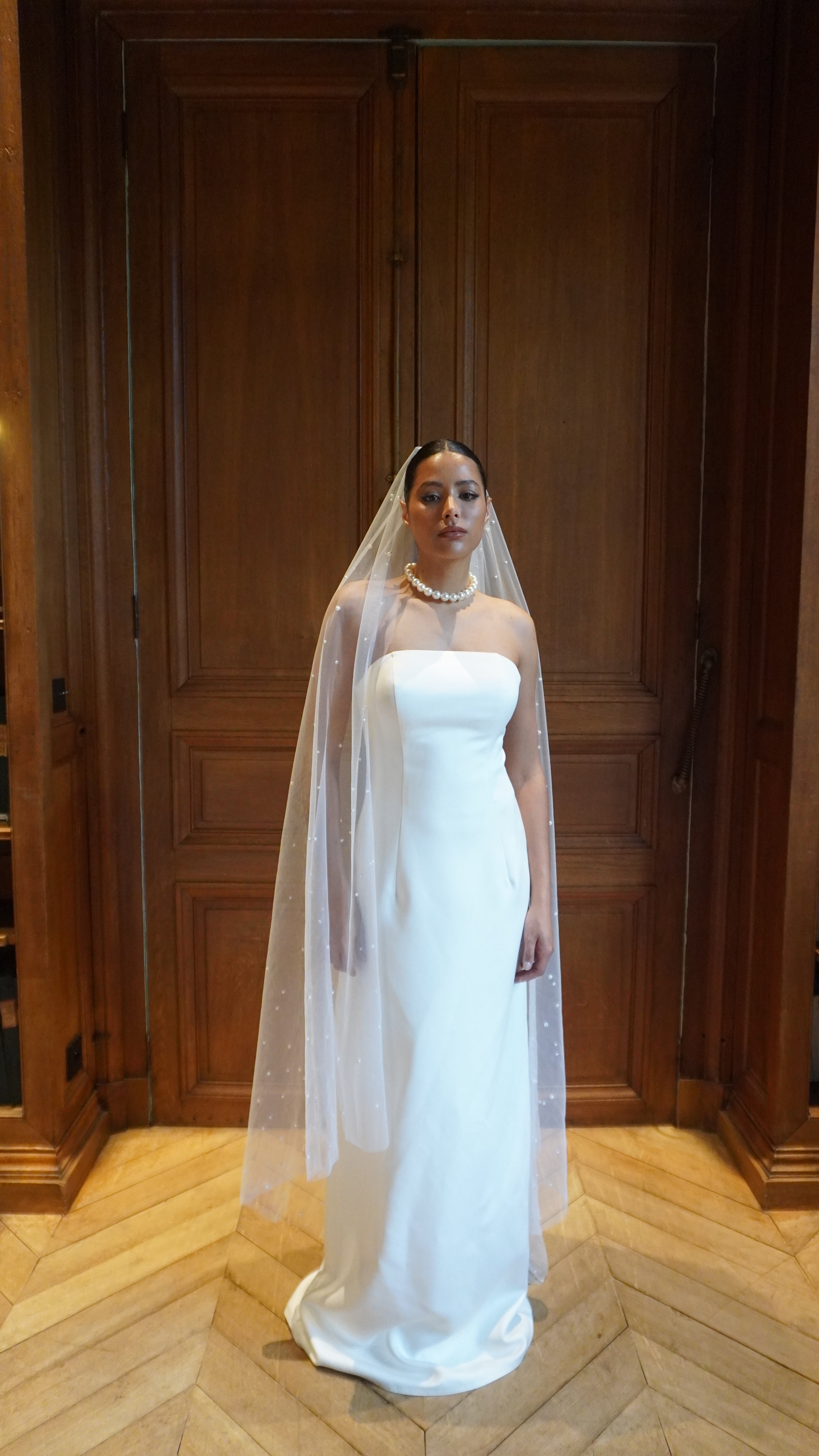 Strapless front-view straight wedding dress with a slight train and an elegant, modern cut.