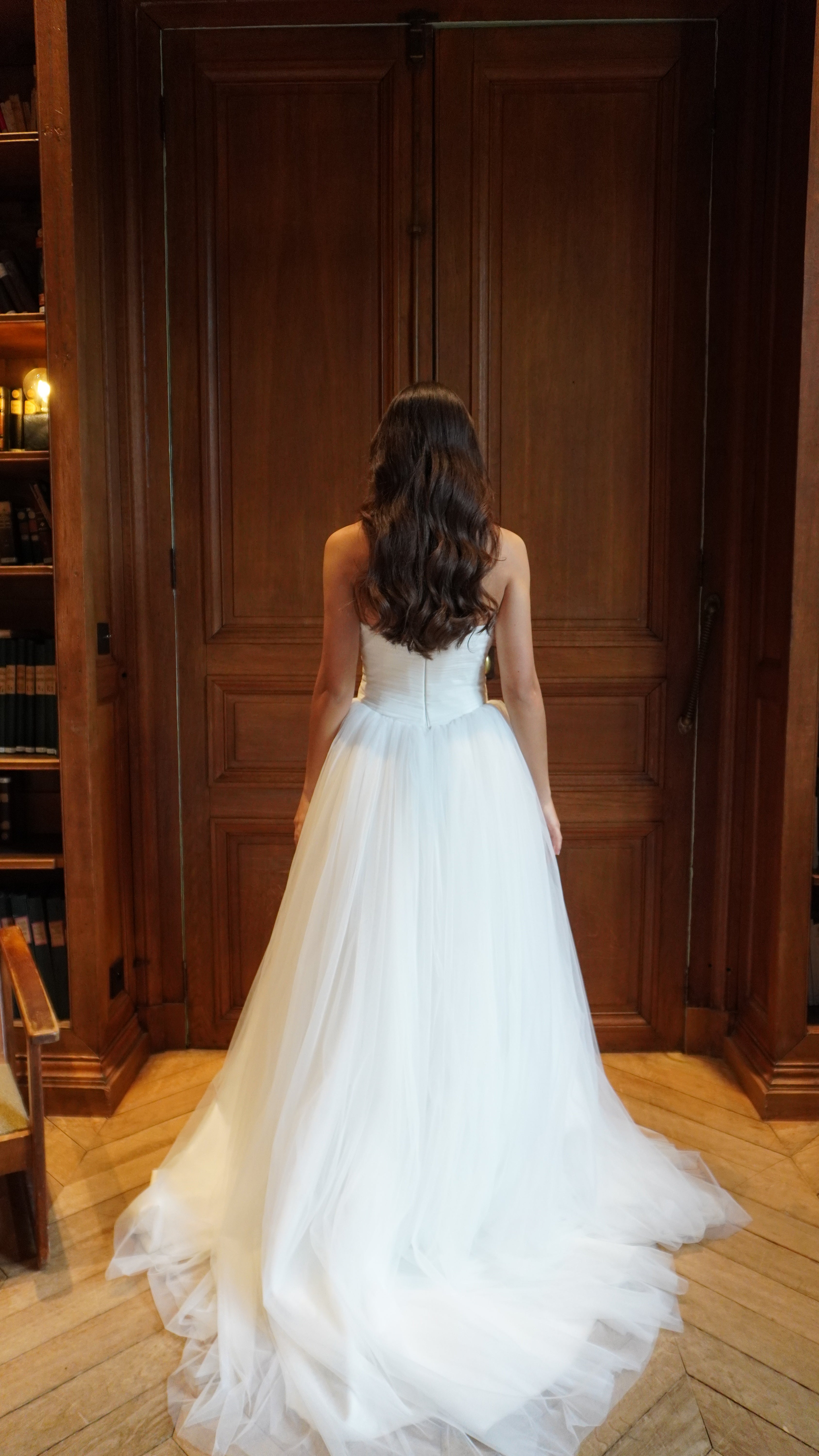 Strapless princess wedding gown in tulle seen from the back, revealing a majestic fall and delicate finishes.