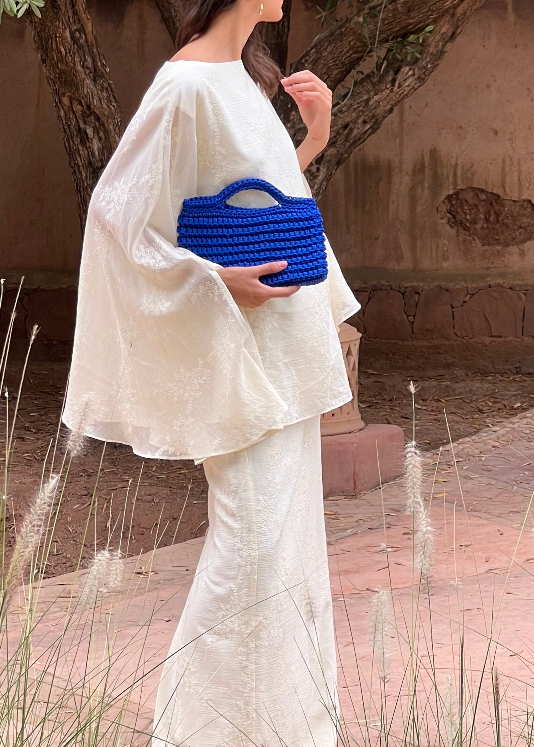 Zoom on a model wearing a midnight blue crochet square bag, handmade in Marrakech