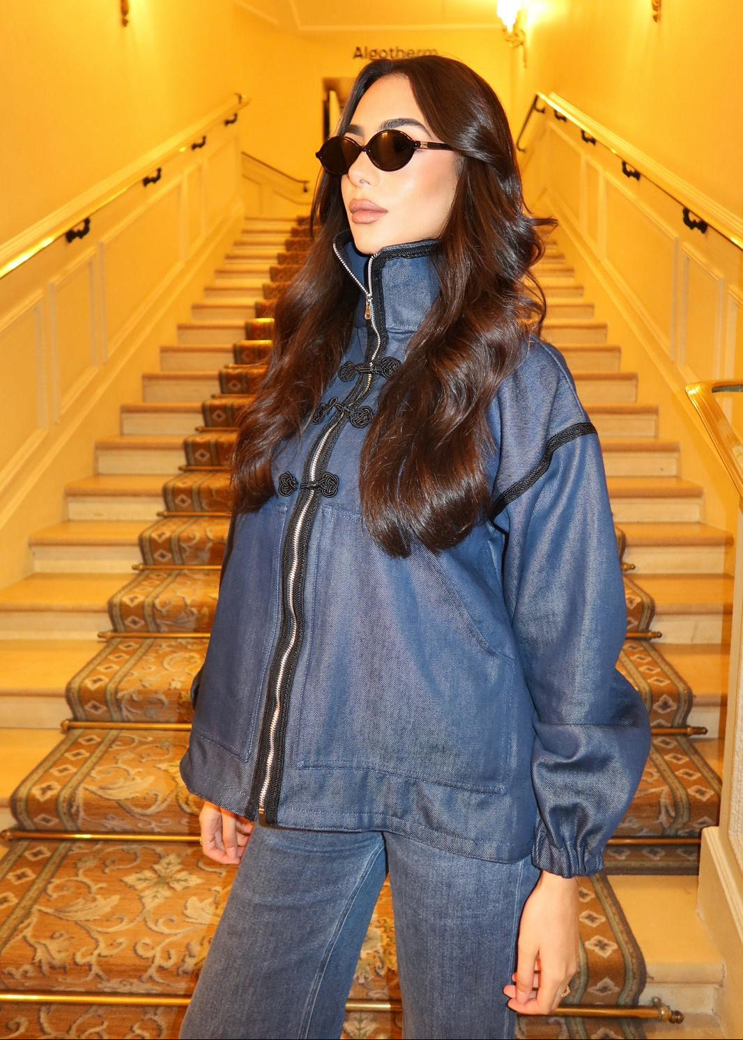 Close-up of the denim jacket's central zipper with black sfifa and Moroccan taîria details.