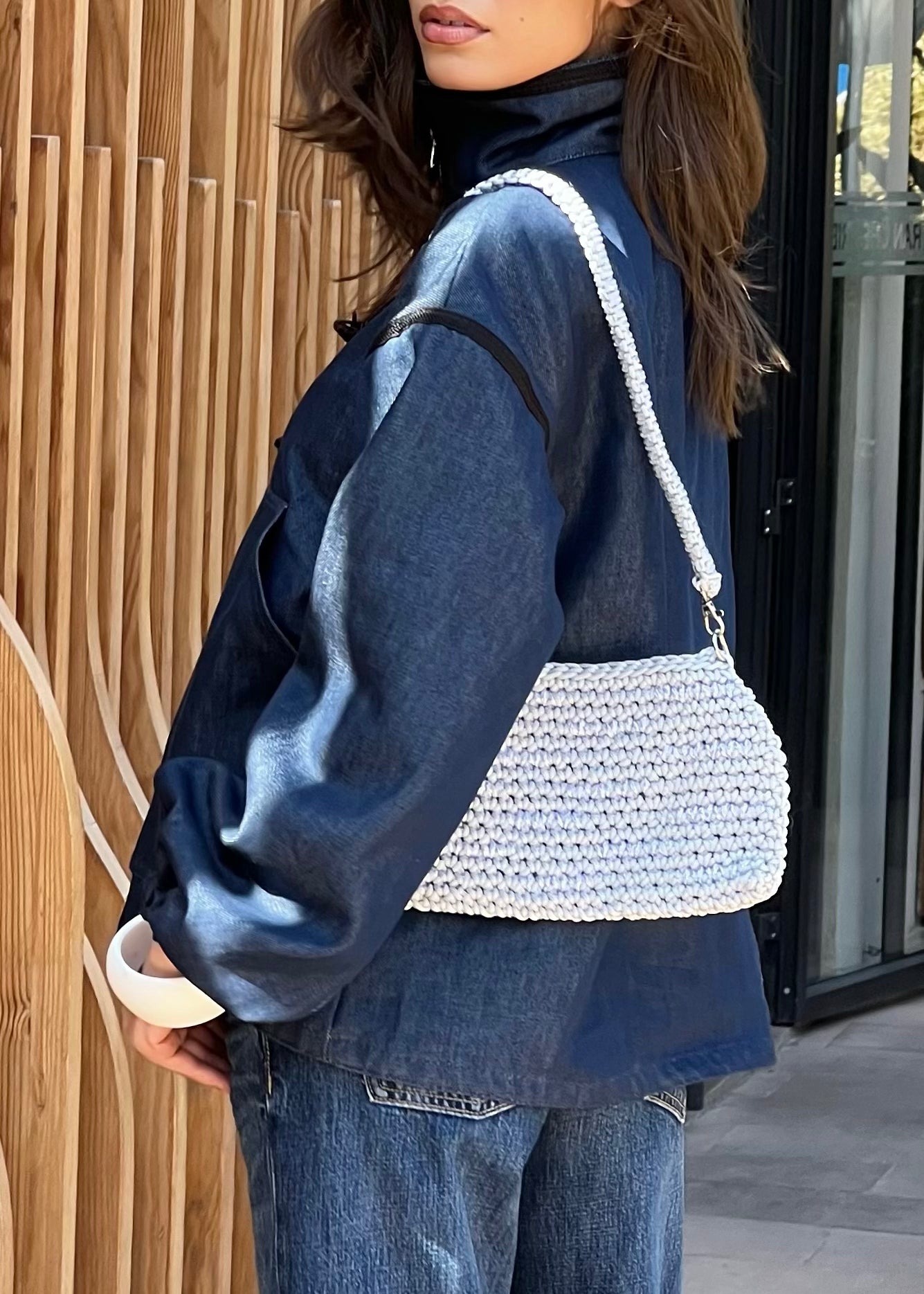 Profile of denim zip-up jacket, black sfifa along edges and Moroccan taîria on sleeves and collar