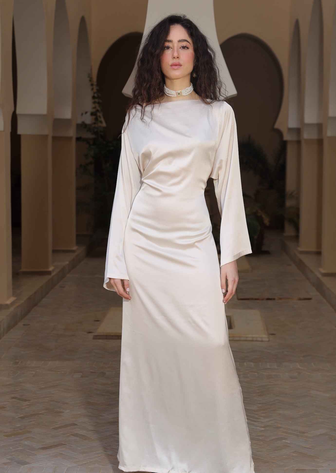 فستان بيج من الساتان الناعم مع سفيفة على الياقة، من الأمام.