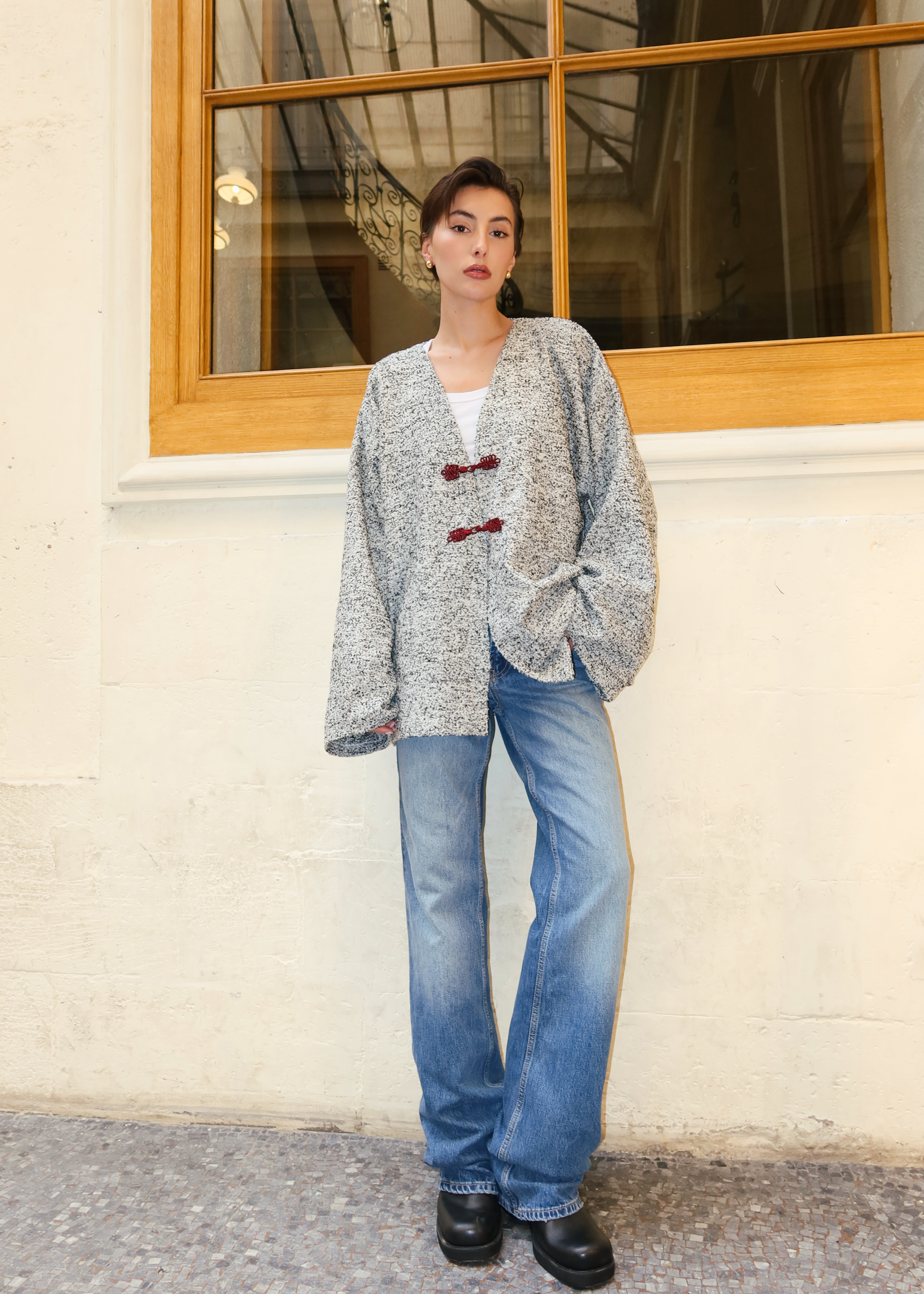 سترة من الصوف المجعد باللونين الرمادي والأسود مصورة بالكامل، مع خطافات باللون العنابي وتصميم أنيق