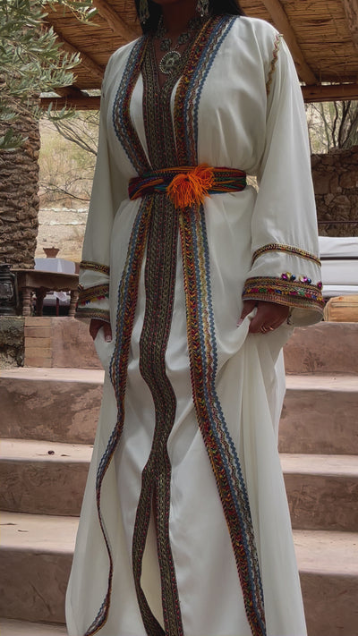 عرض القفطان القبائلي المصنوع من الموسلين الأبيض أثناء الحركة، مما يبرز خفة القماش وبراعته.