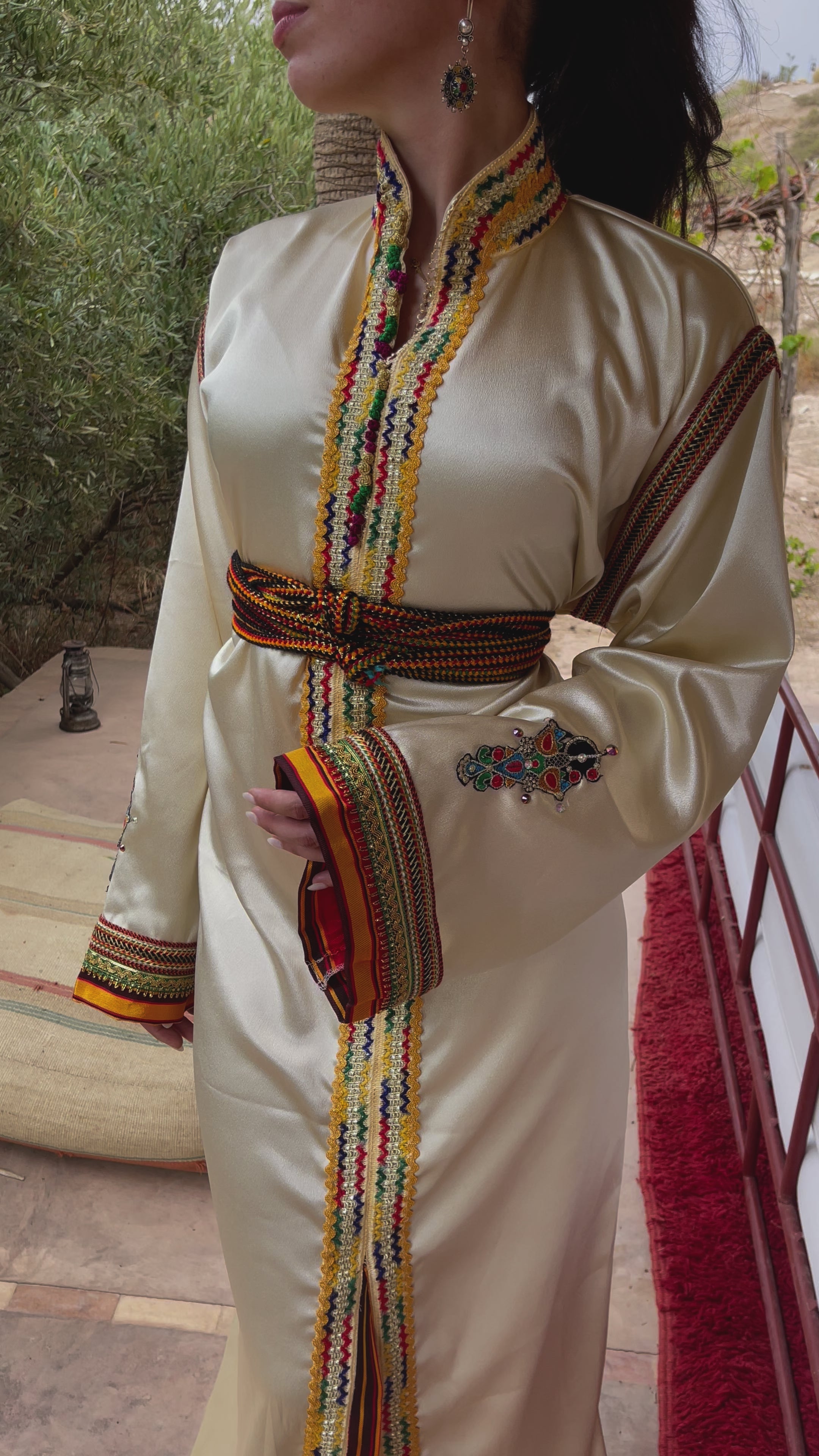 فيديو لقفطان قبائلي باللون البيج مع ياقة ضابط، ترتديه إحدى عارضات الأزياء، يبرز التطريز التقليدي والقصّة المستقيمة والأناقة الرصينة للتصميم.