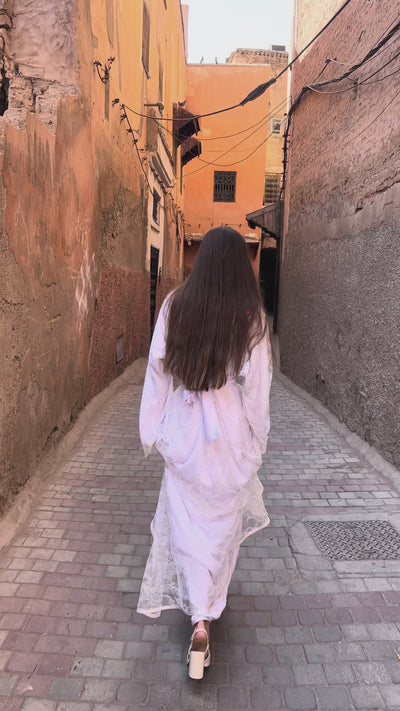 فيديو لقفطان الزفاف من دانتيل كاليه الأبيض والقصّة الأنيقة وتفاصيل الدانتيل الناعمة، مما يبرز الانسدال الانسيابي والتشطيبات المصنوعة يدوياً.