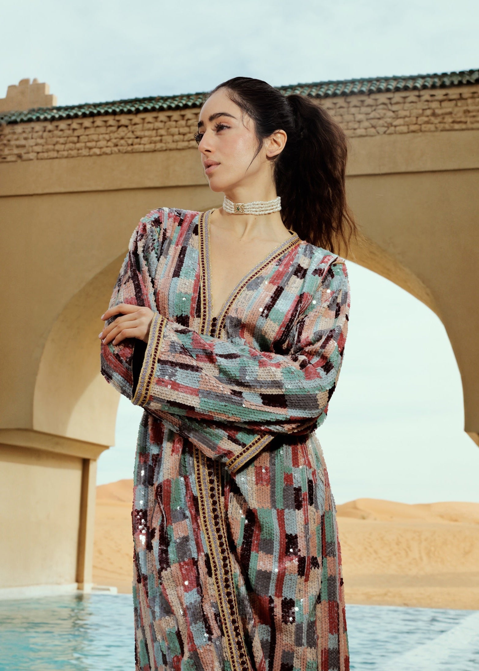 Caftan en sequins multicolores porté en mouvement, effet scintillant et fluide.