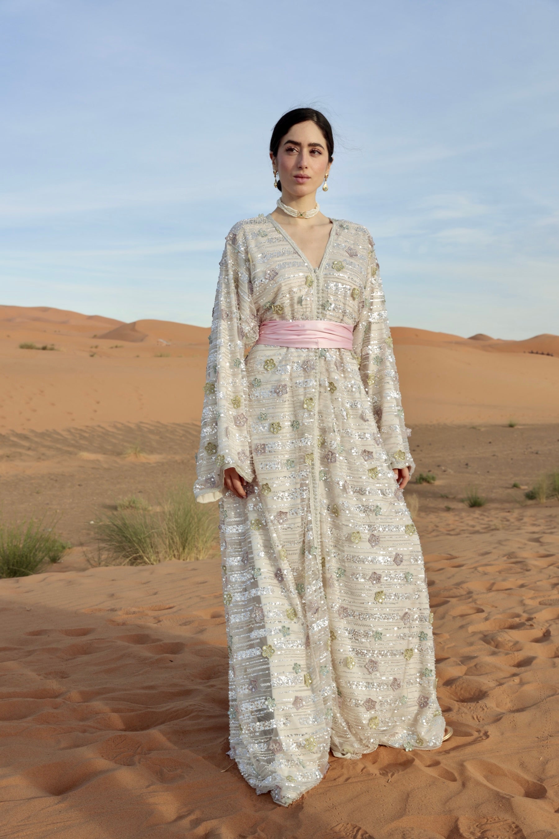 Caftan en tulle perlé argenté floral porté en vue trois-quarts, mettant en valeur les perles et motifs.