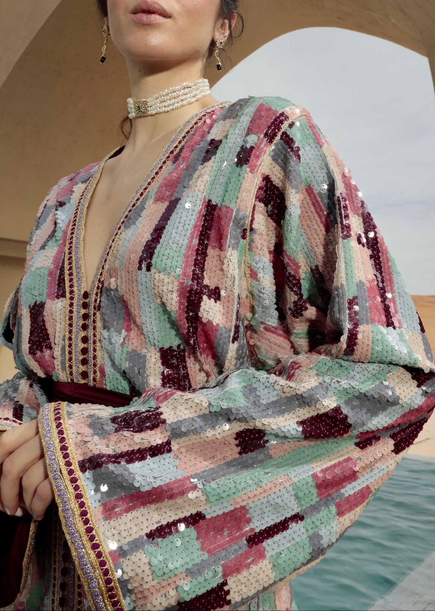 Détail des finitions soignées d’un caftan en sequins multicolores.