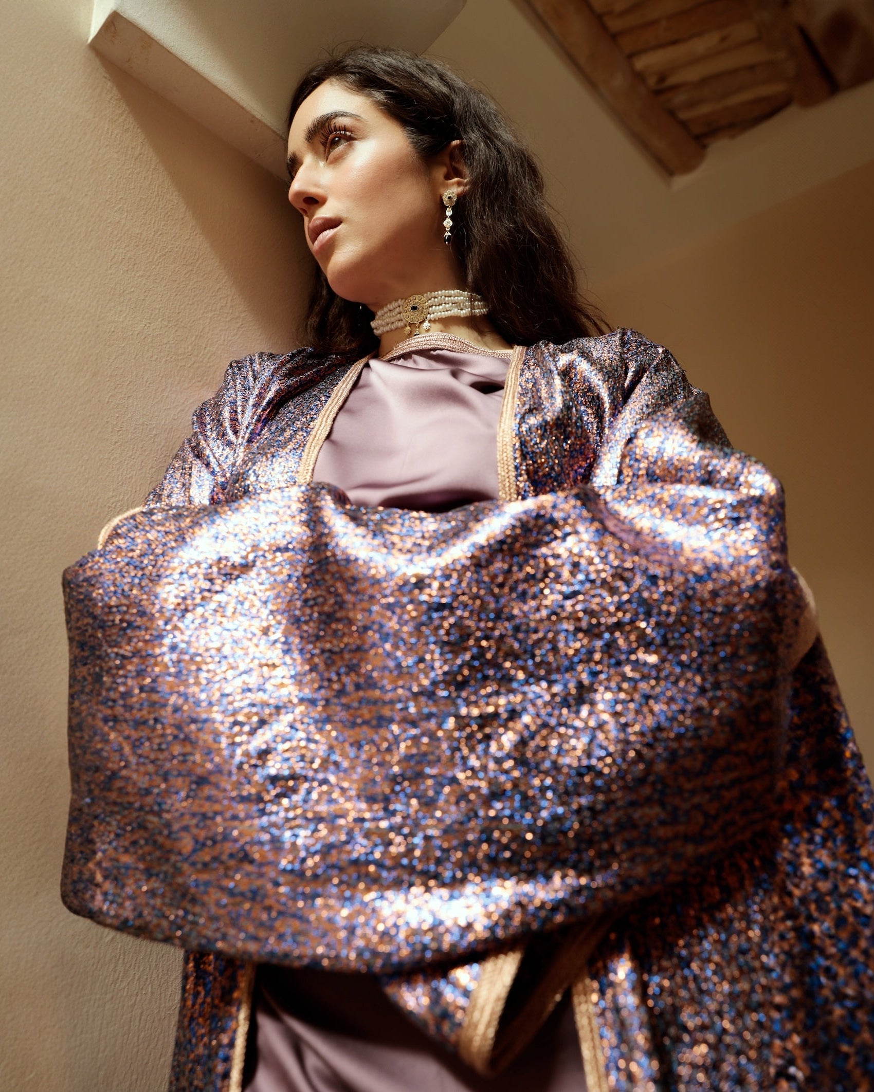 Détail de la manche kimono d’une abaya en jacquard lurex violet et bleu.