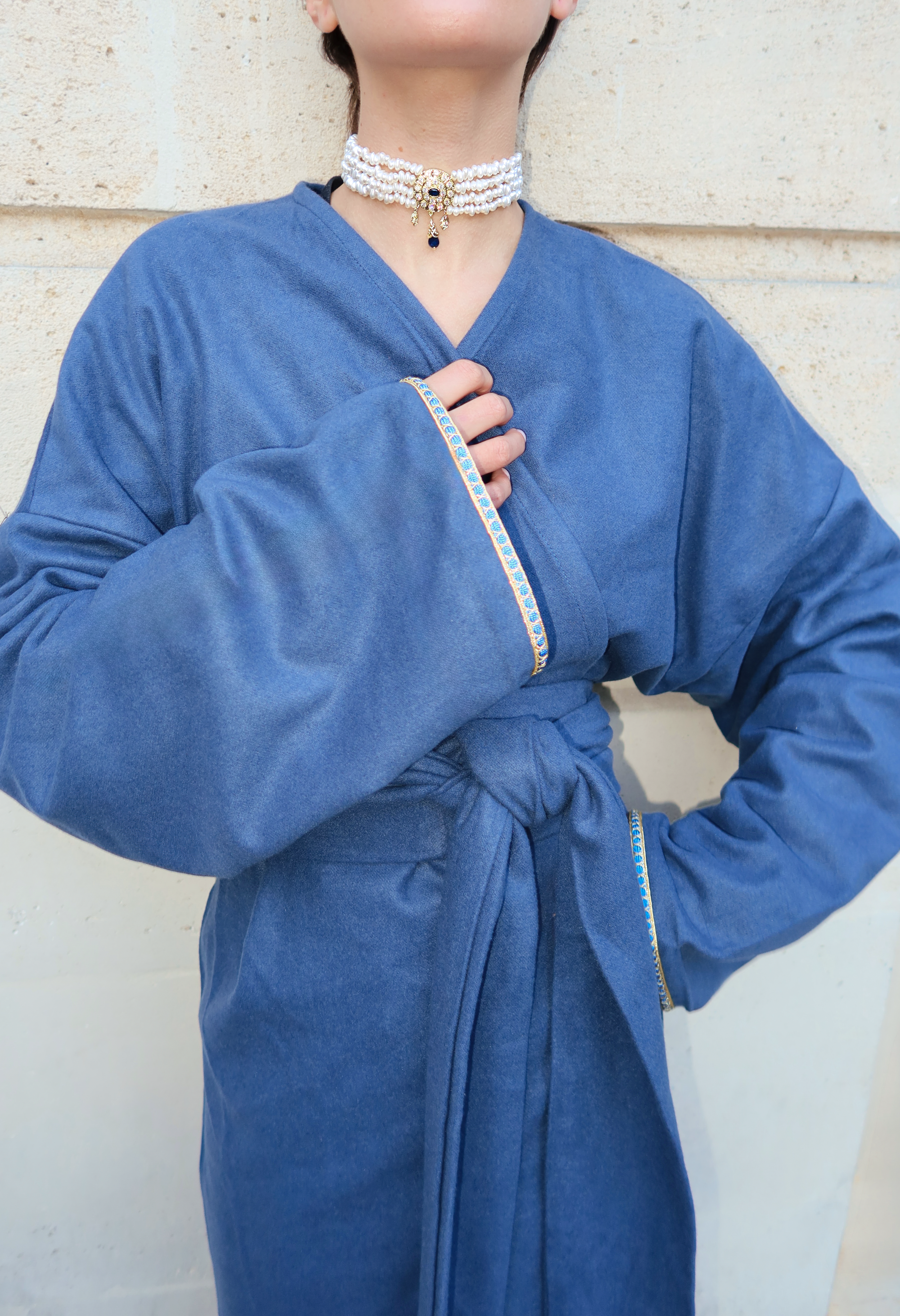 Gros plan sur le détail sfifa d’un gilet long en cachemire bleu