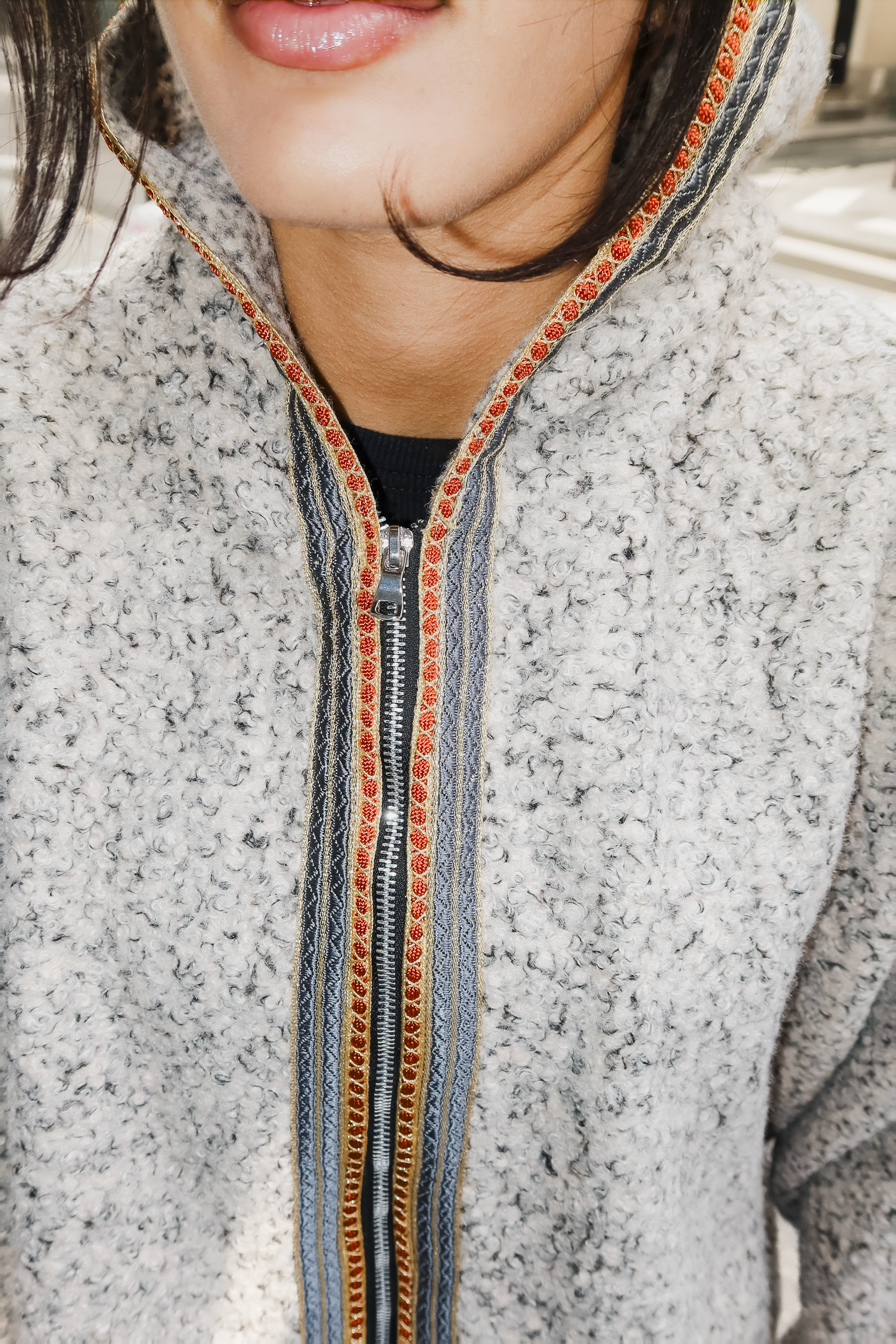 Détail de la sfifa marocaine orange et grise sur sweat gilet en laine bouclée beige