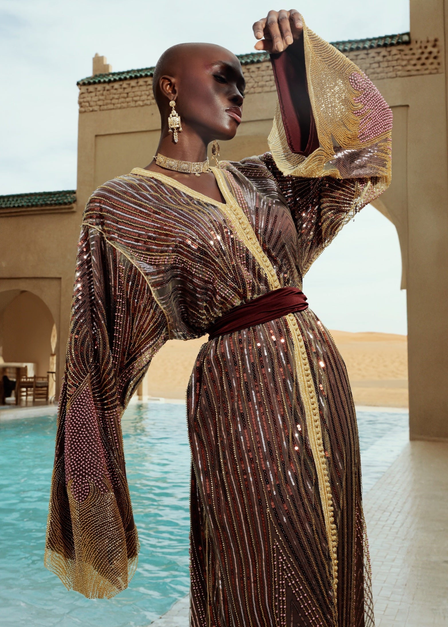 Gros plan sur les perles brodées du tulle doré et bordeaux d’un caftan