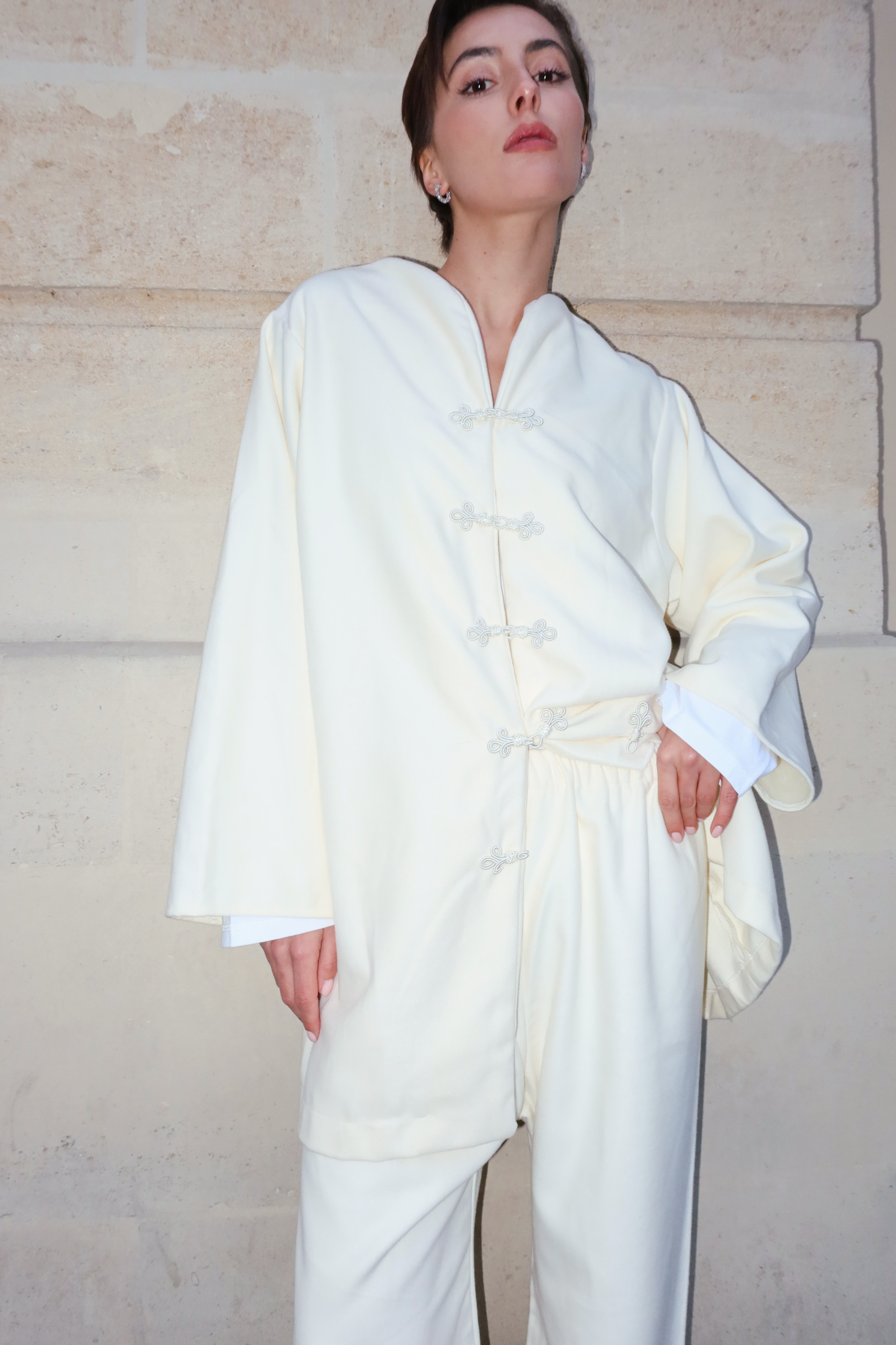 Ensemble en cachemire beige en mouvement révélant la douceur du cachemire et des boutons marocains élégants