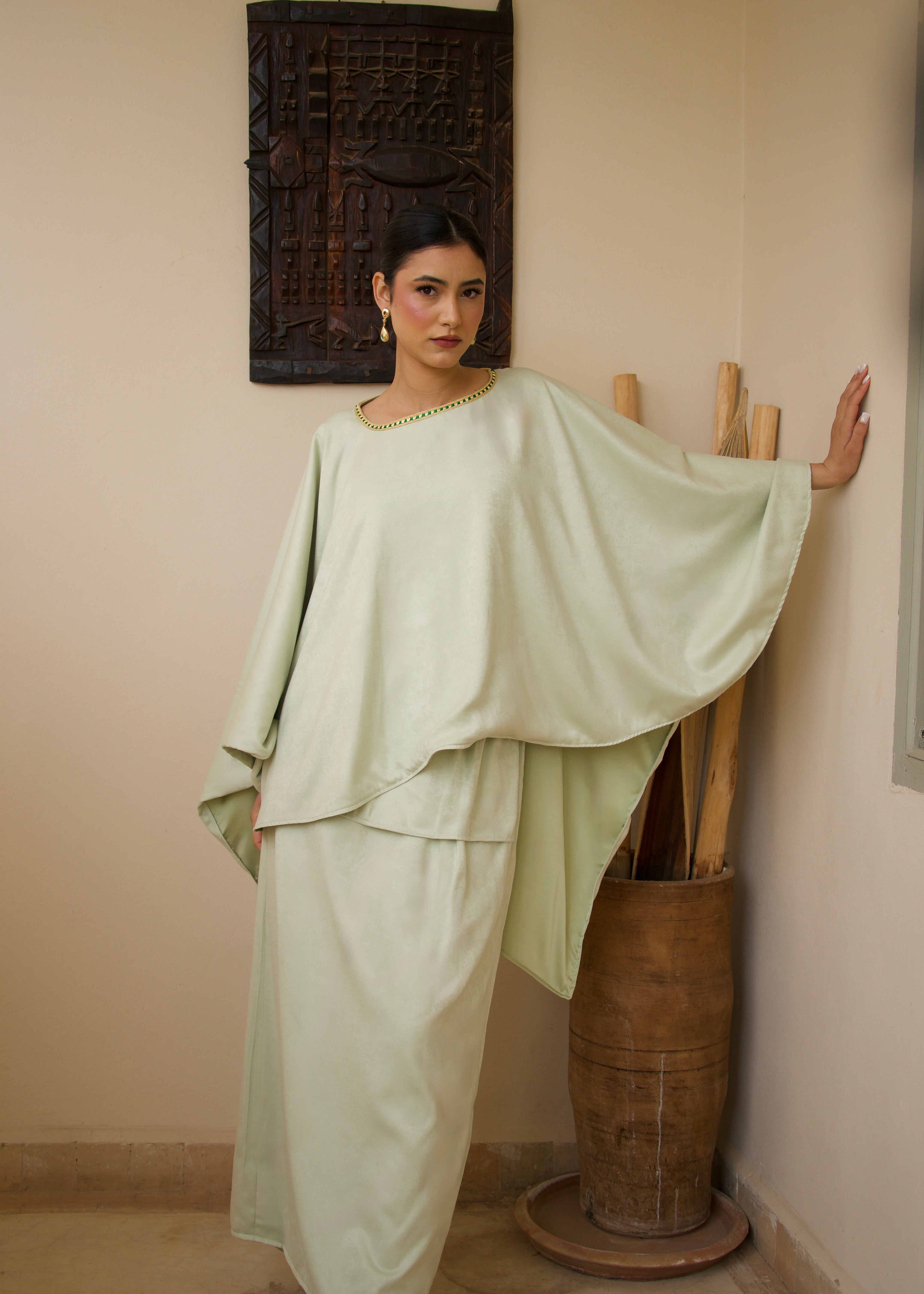 Ensemble vert composé d’une cape et d’une jupe en soie mlifa, vue de face.