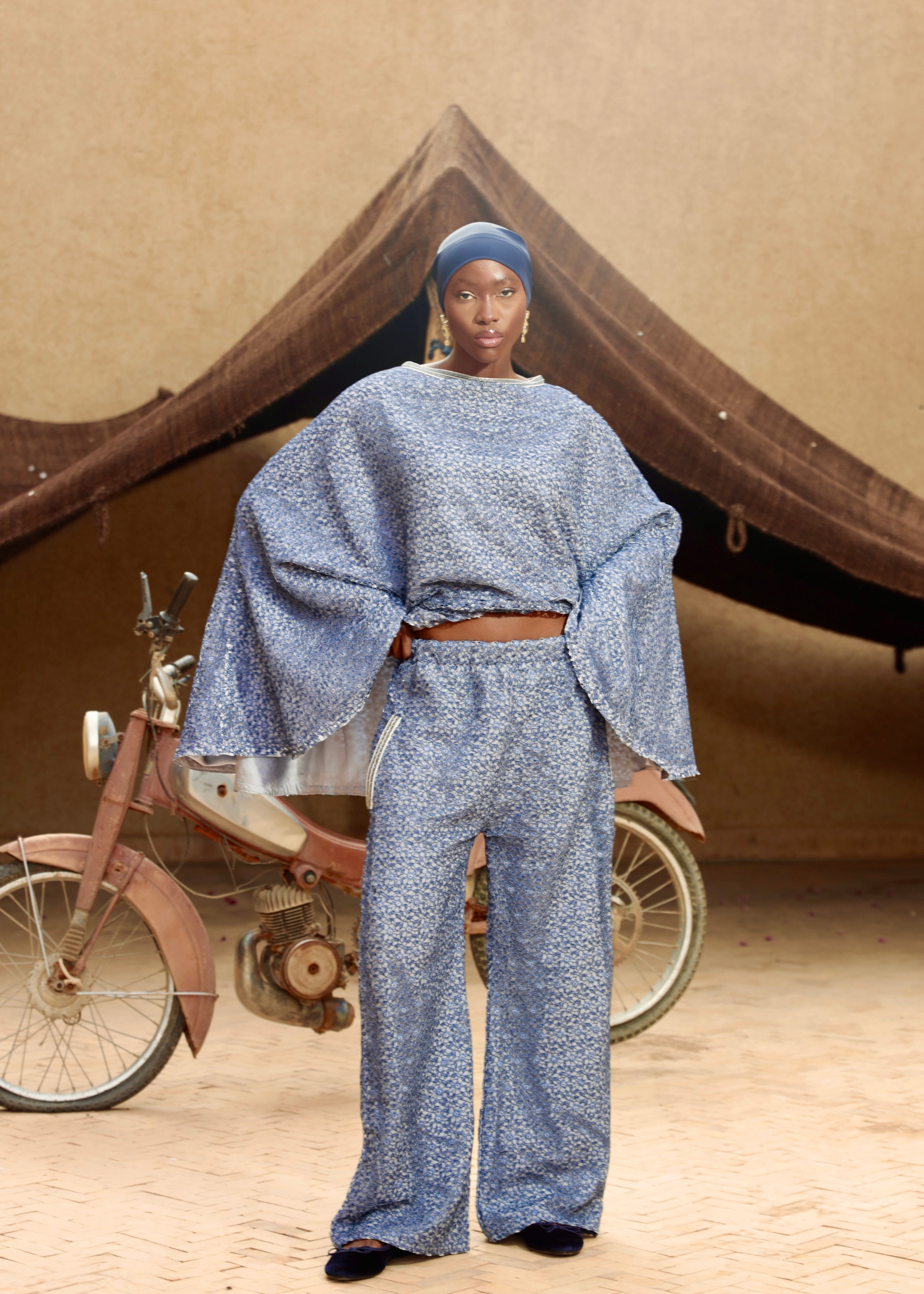 Set consisting of a cape and blue lace pants with a bow, front view.