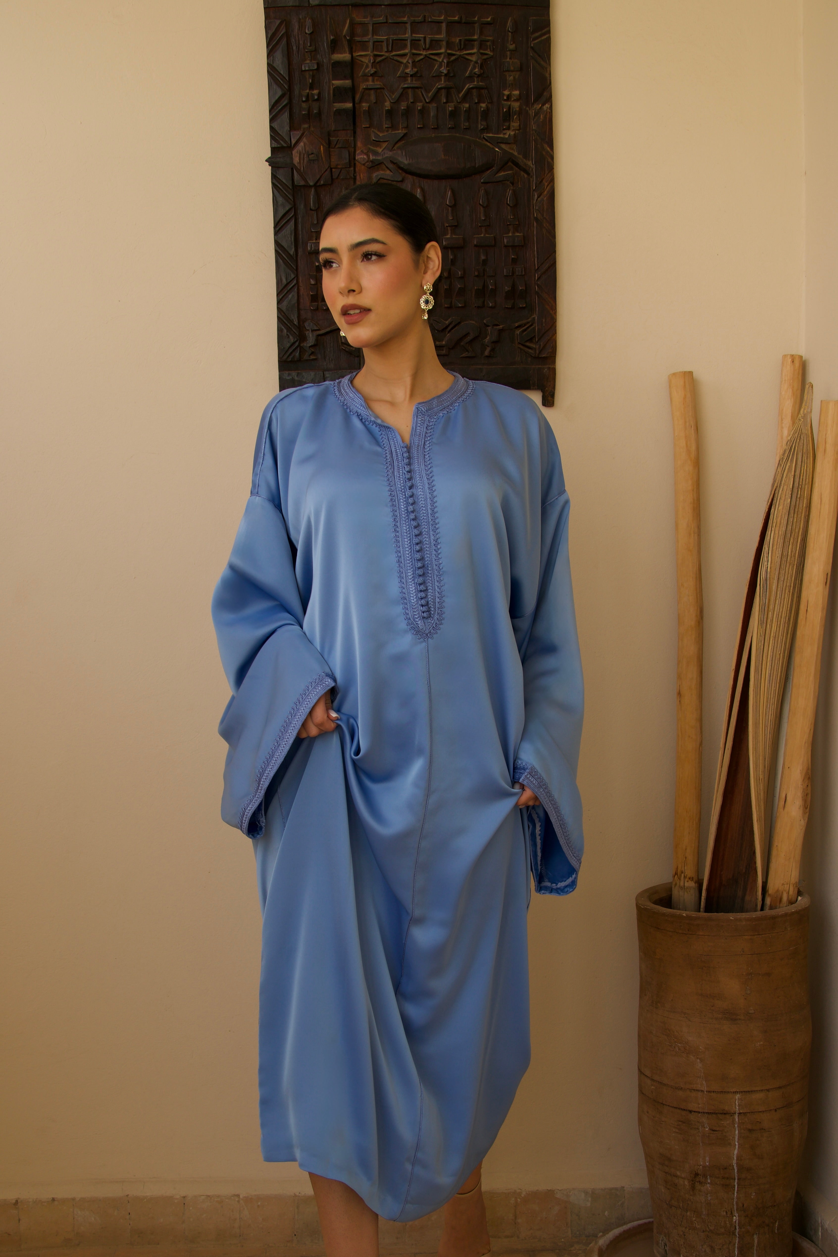 Jellaba en satin duchesse bleu portée en mouvement, tissu fluide et élégant.