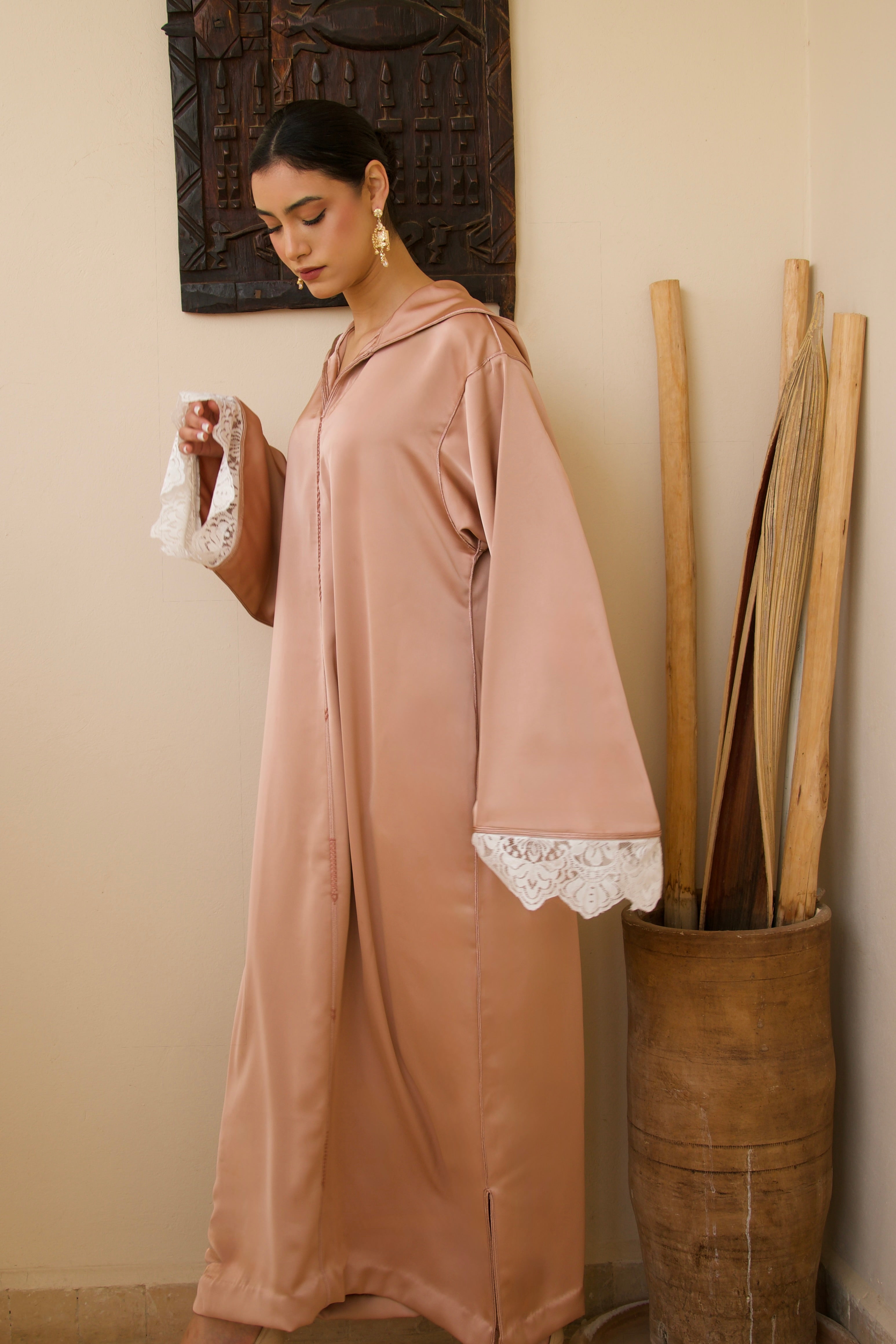 Jellaba rose en satin duchesse portée en mouvement, tissu fluide et élégant.