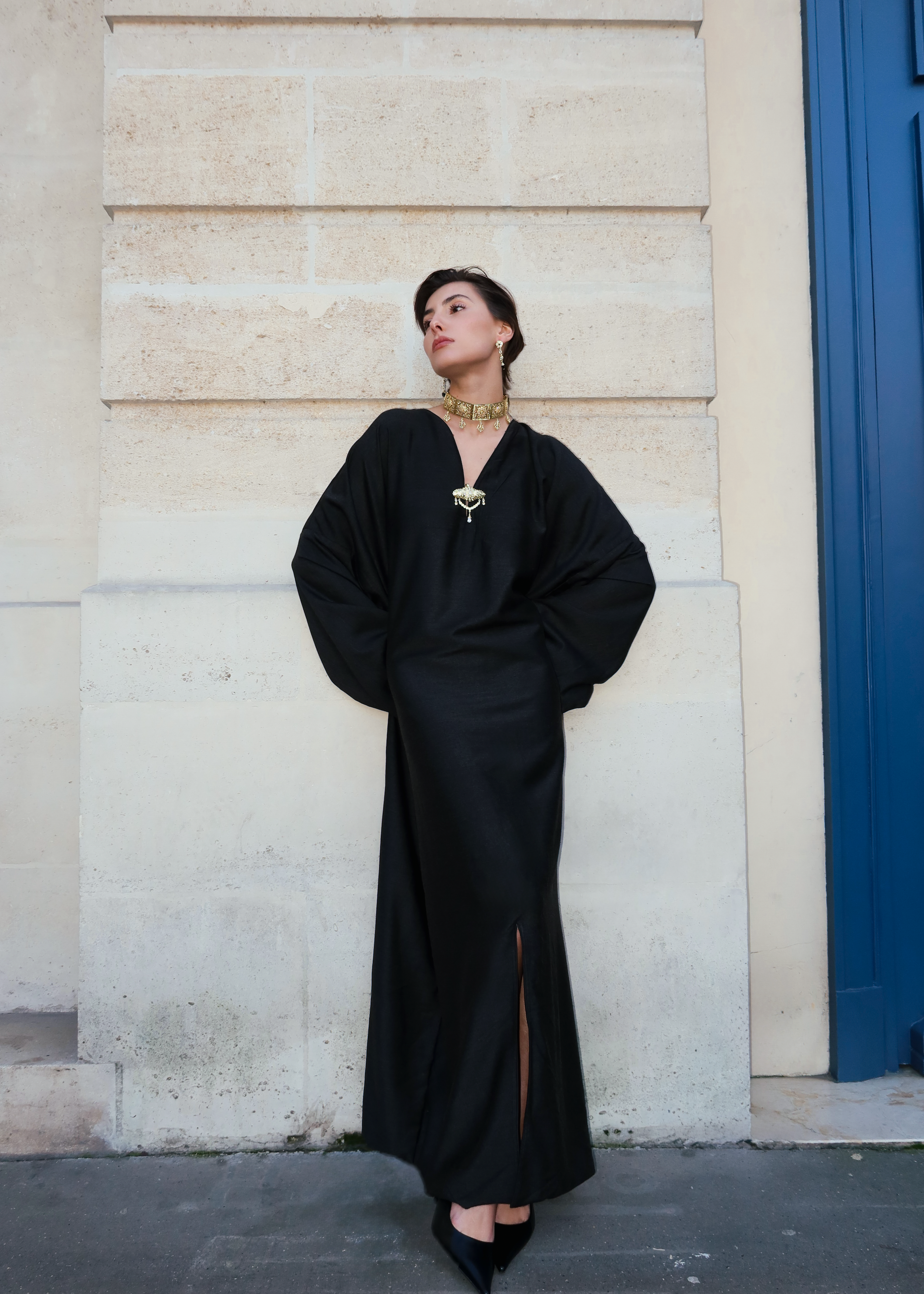 Robe traditionnelle en soie Mlifa grise portée de face, ornée d’une élégante broche marocaine artisanale