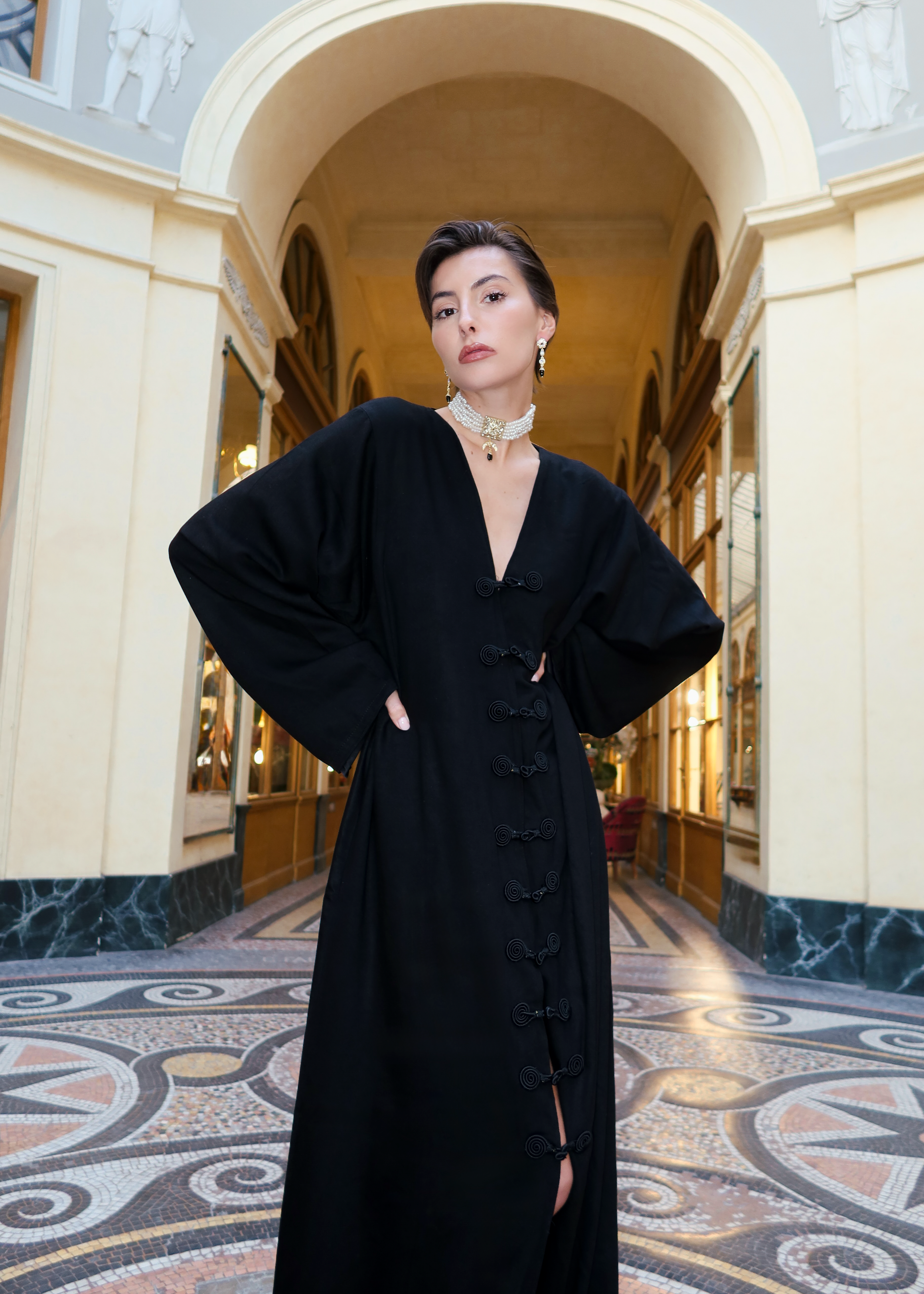 Robe traditionnelle en soie Mlifa noire portée de face, ornée de crochets marocains artisanaux