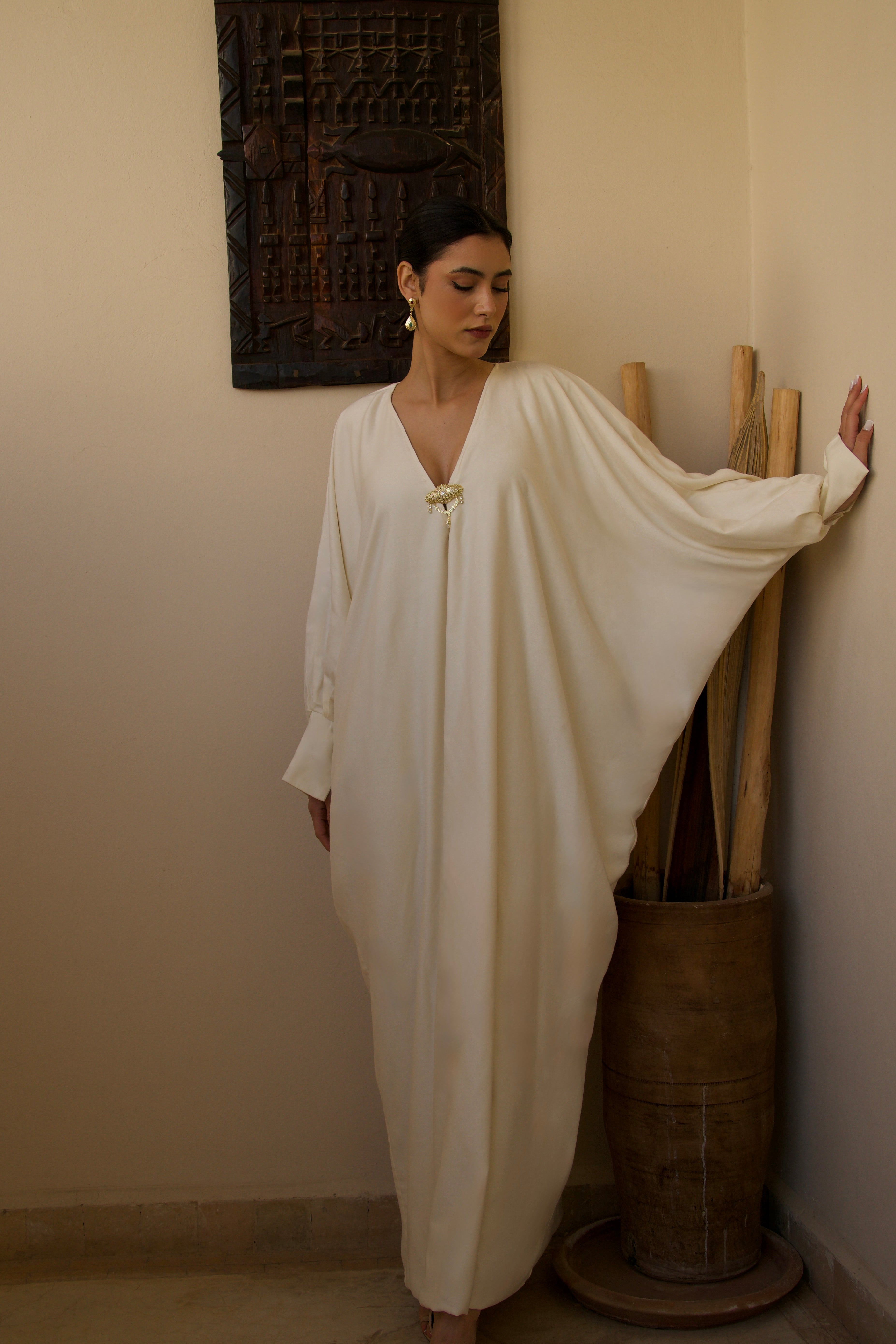 Robe longue blanche en soie mlifa portée en mouvement, tissu fluide et élégant.