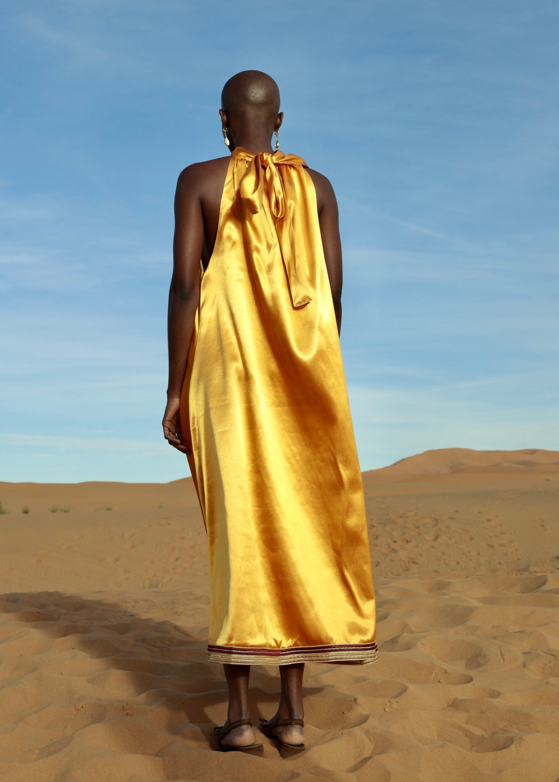 Orange duchesse satin dress adorned with handcrafted sfifa, back view.