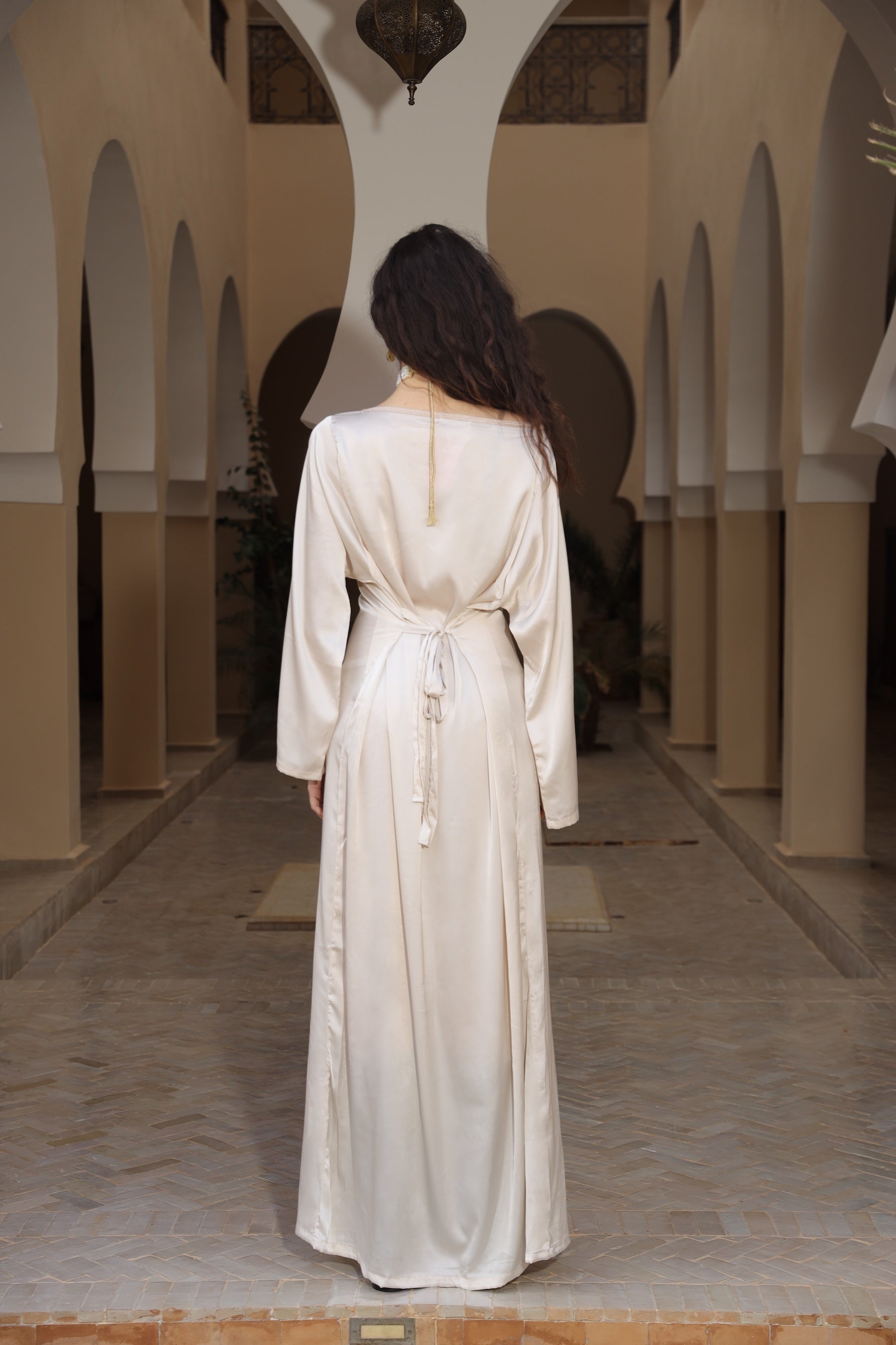 Robe beige en satin fluide à manches longues, vue de dos.