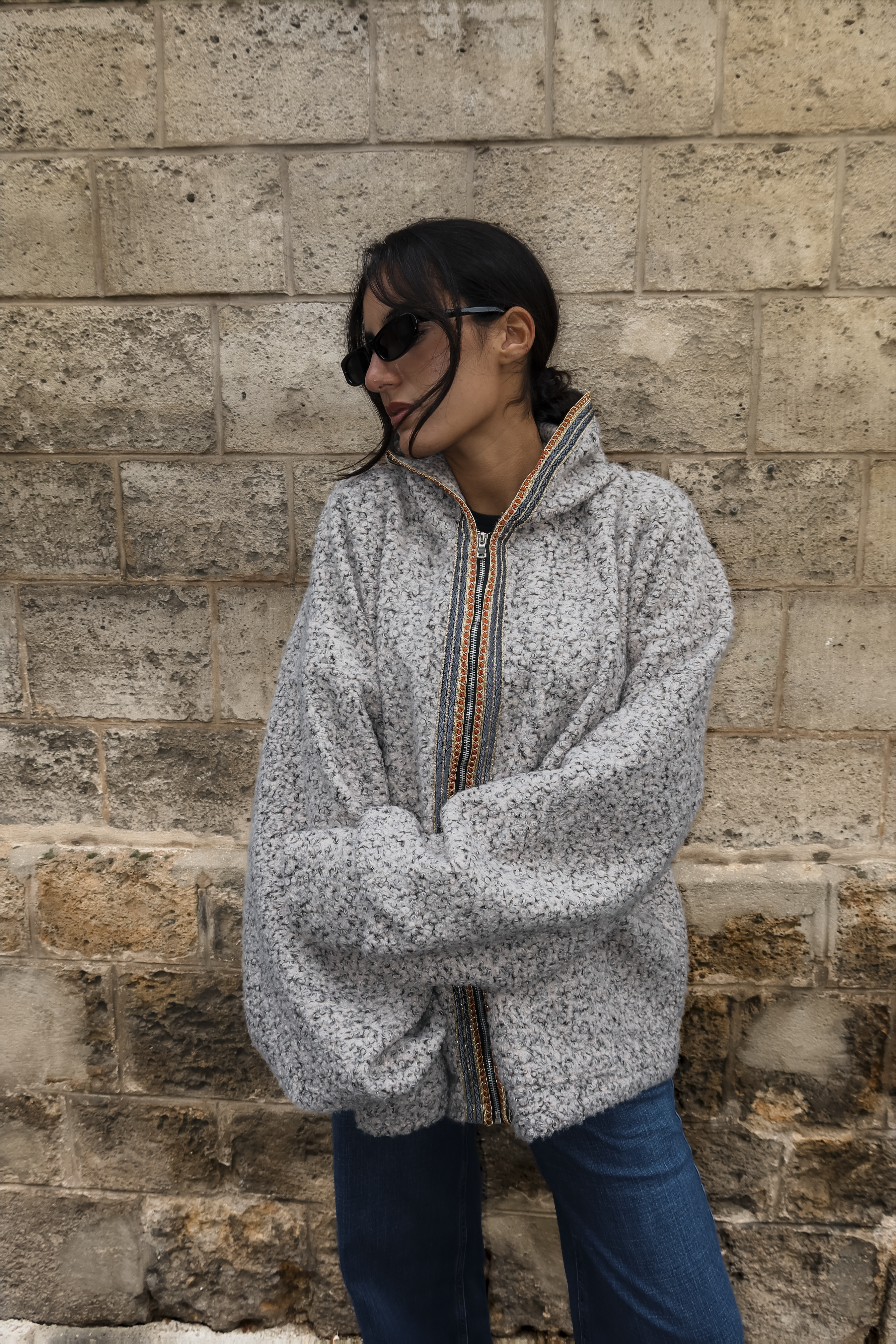 Sweat gilet en laine bouclée beige avec sfifa marocaine orange et grise porté en mouvement