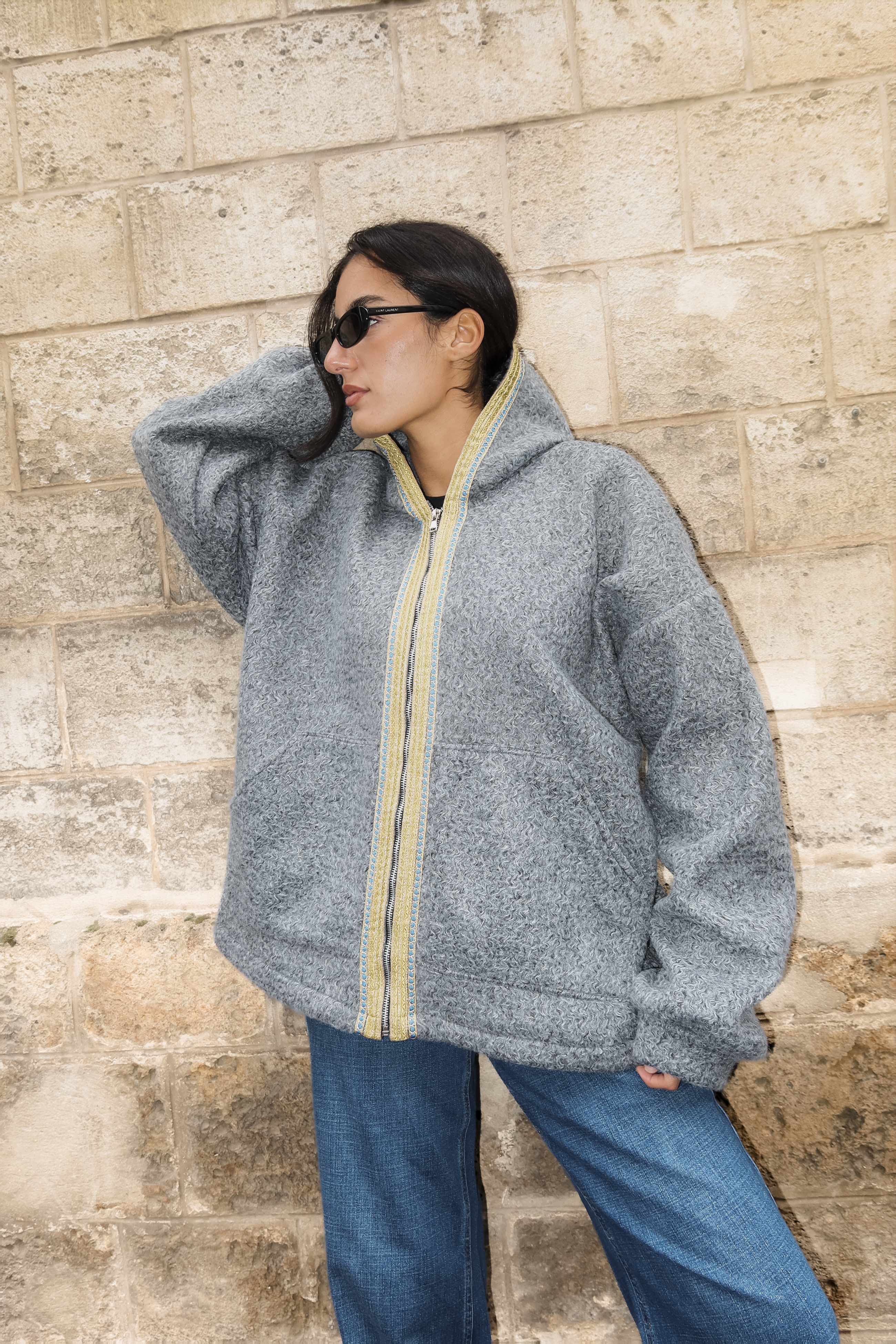 Sweat gilet en laine bouclée grise avec sfifa marocaine verte et bleue porté en mouvement