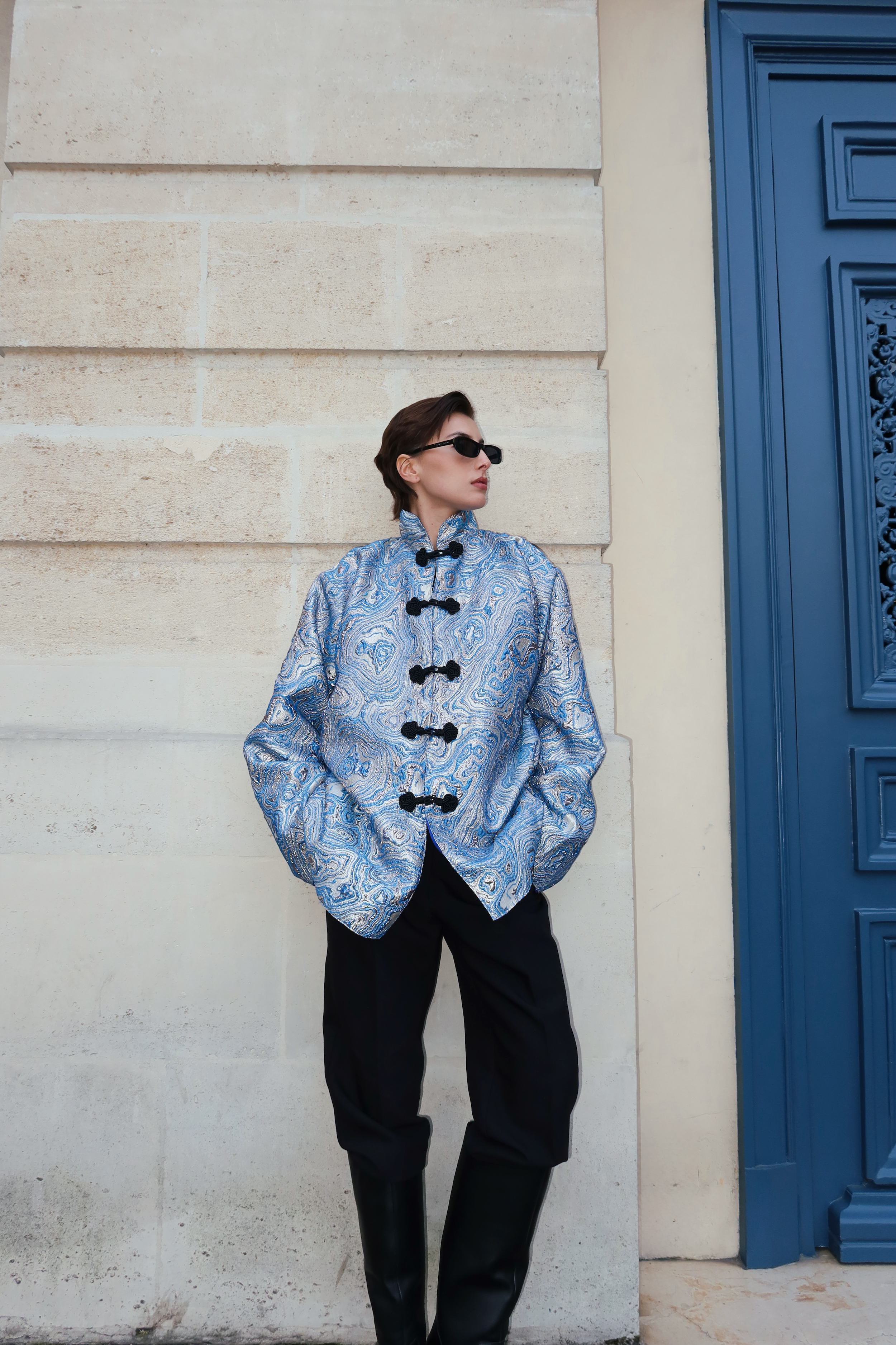 Veste marocaine en brocard bleu portée de face, ornée de crochets marocains noirs artisanaux