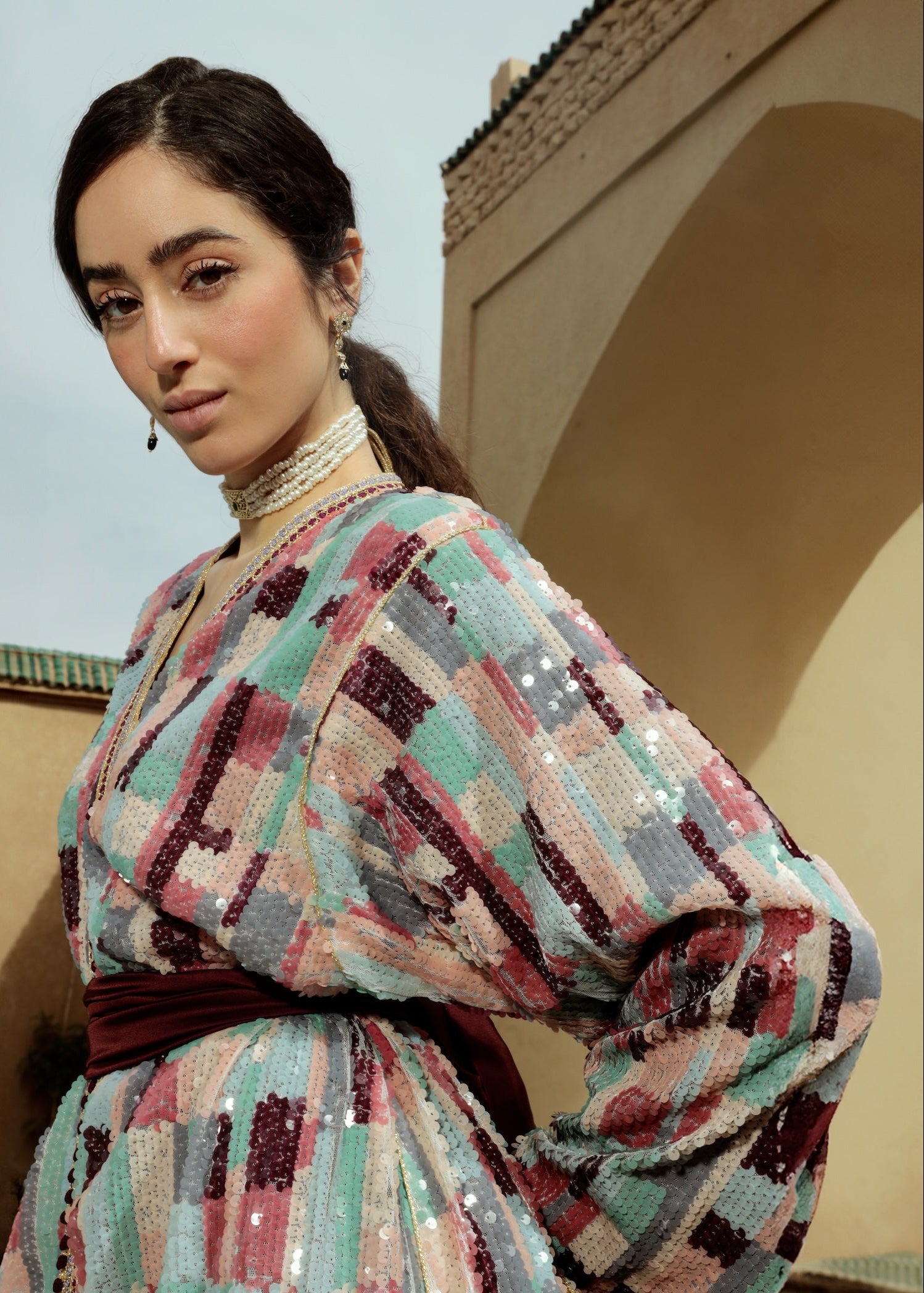 Gros plan sur les sequins multicolores brodés sur un caftan.