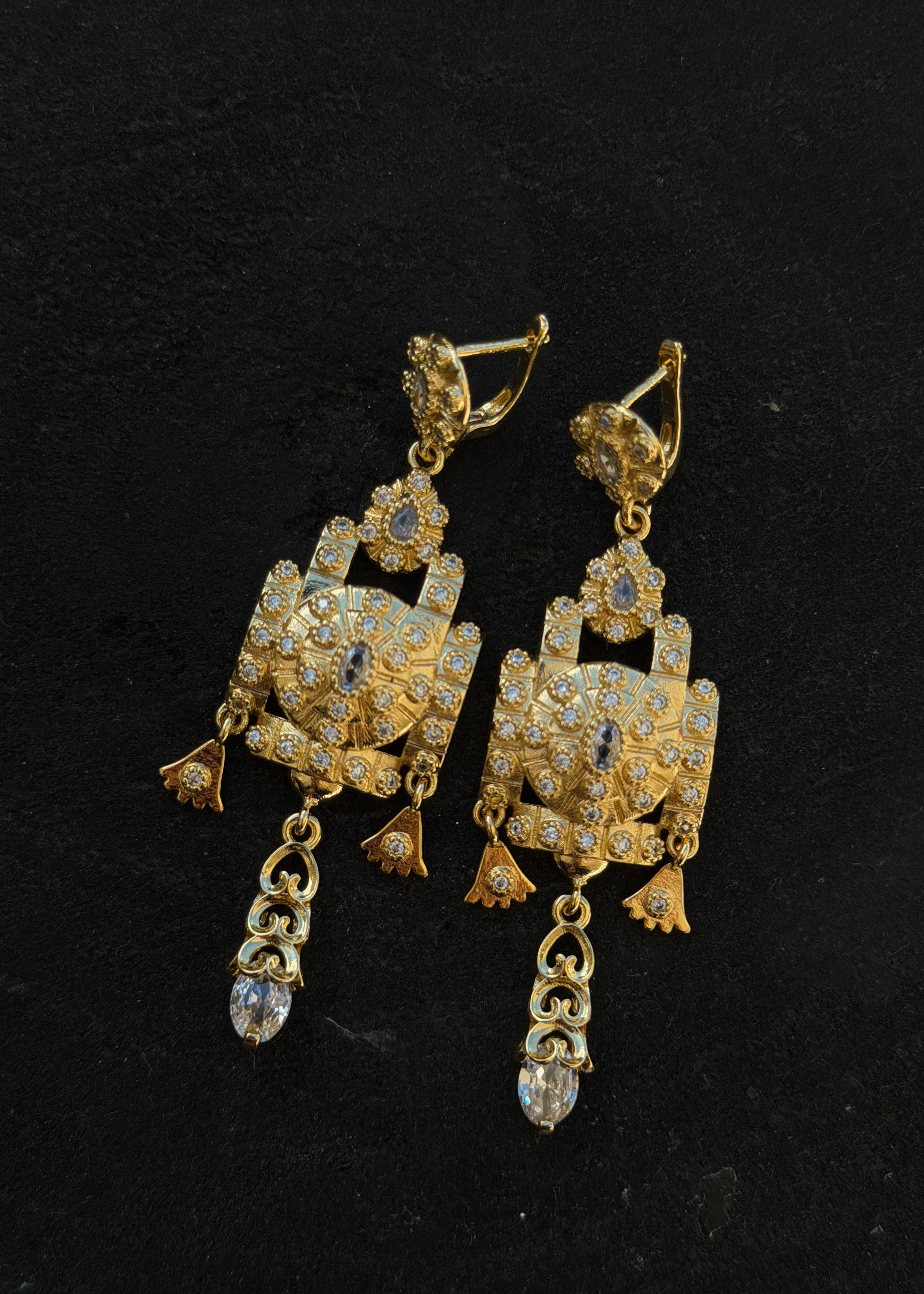 Worn gold chandelier earrings, a striking piece of oriental jewelry that frames the face