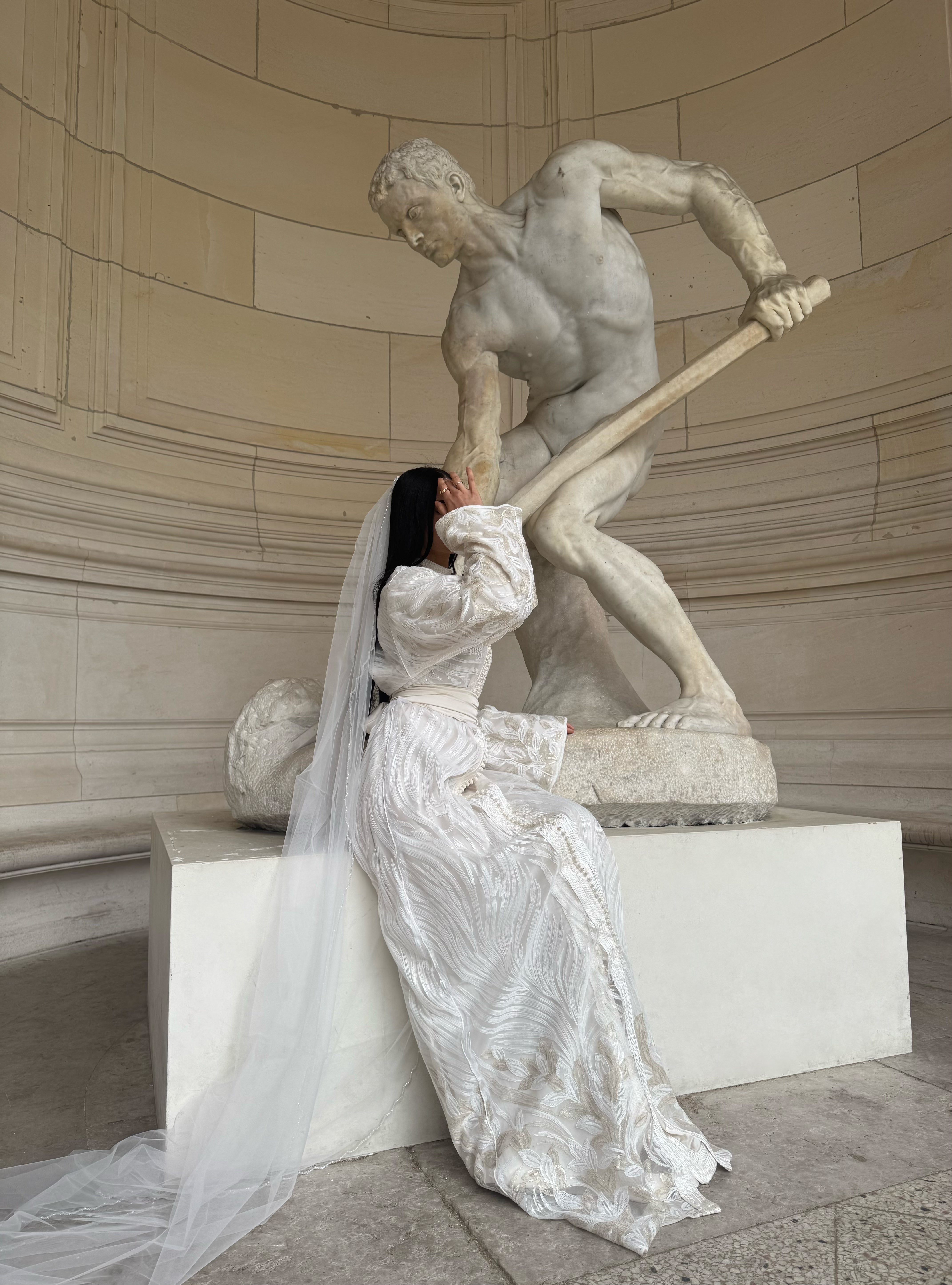 Side view of a textured white Kaftan worn while seated
