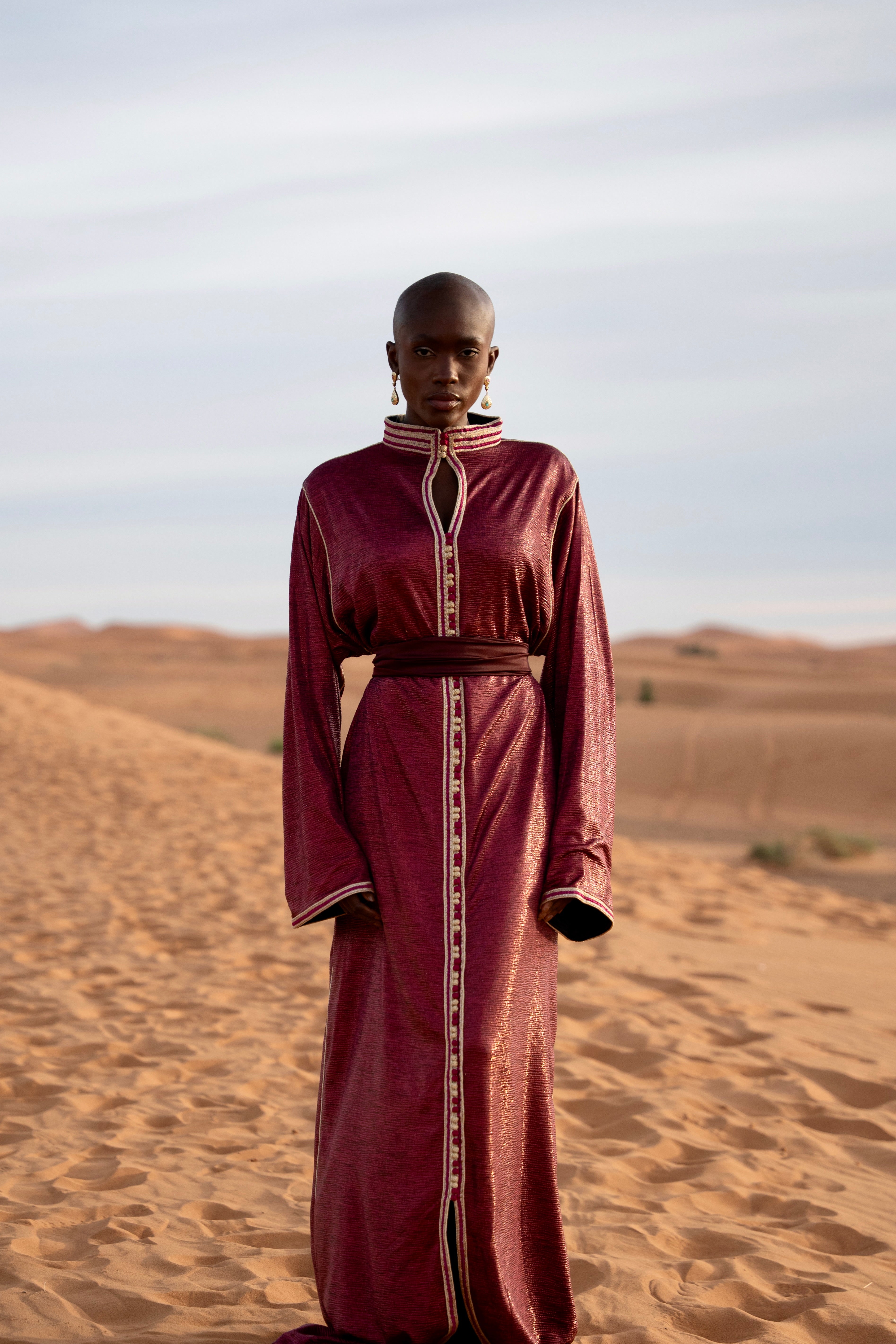 Caftan en jersey violet vu de face dans le désert avec ceinture ton sur ton
