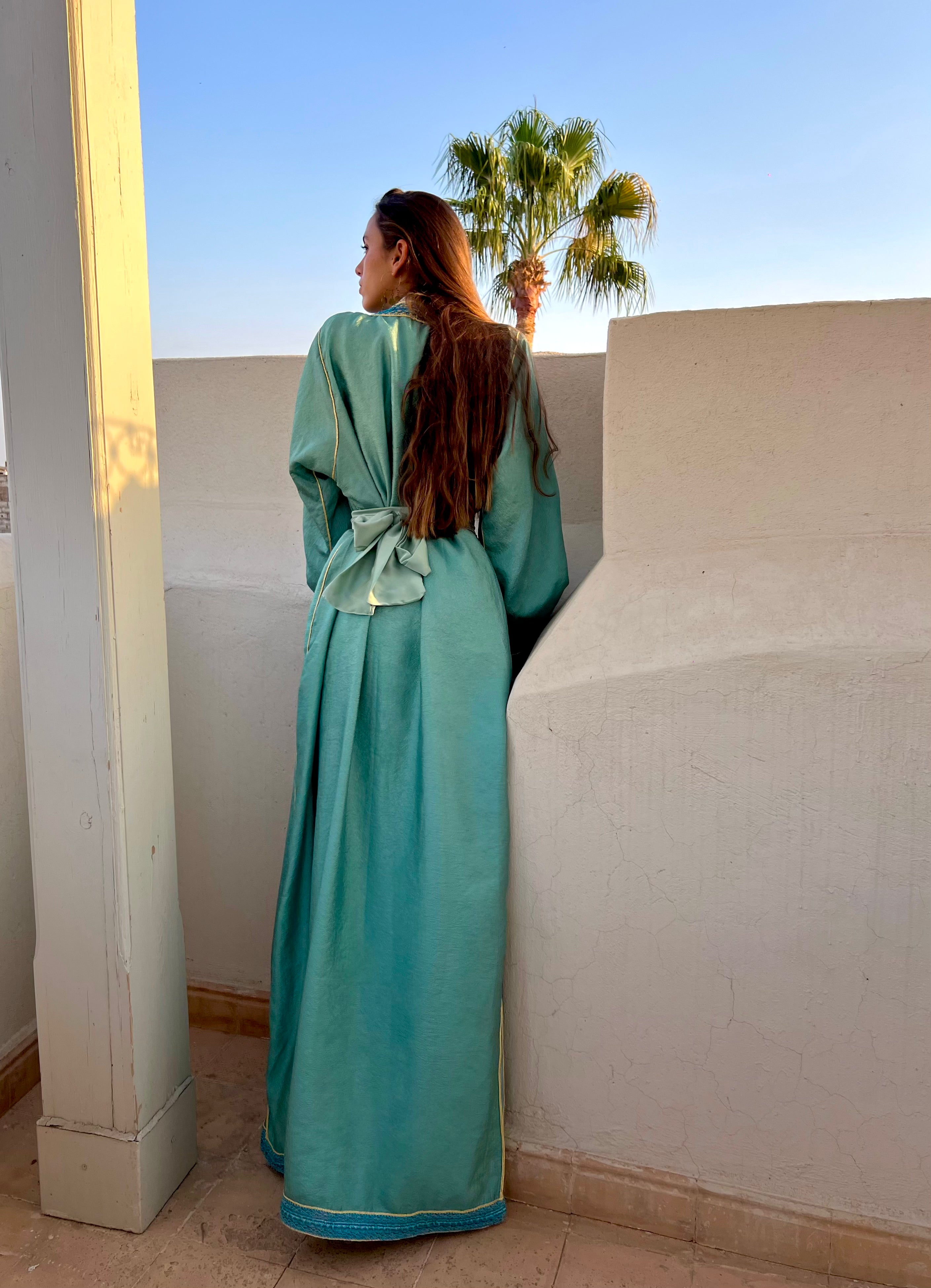Dos du caftan moderne en satin vert d’eau, drapé élégant et tombé naturel du tissu satiné