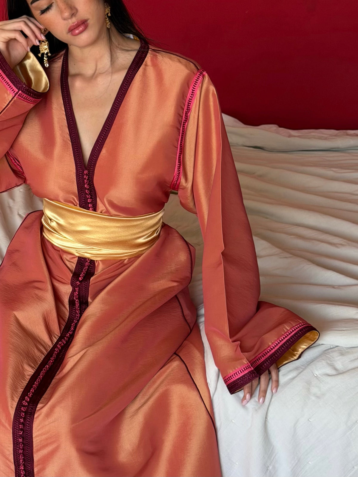 Caftan Pêche à Sfifa Prune — Vue assise montrant le tissu pêche et les finitions prune.