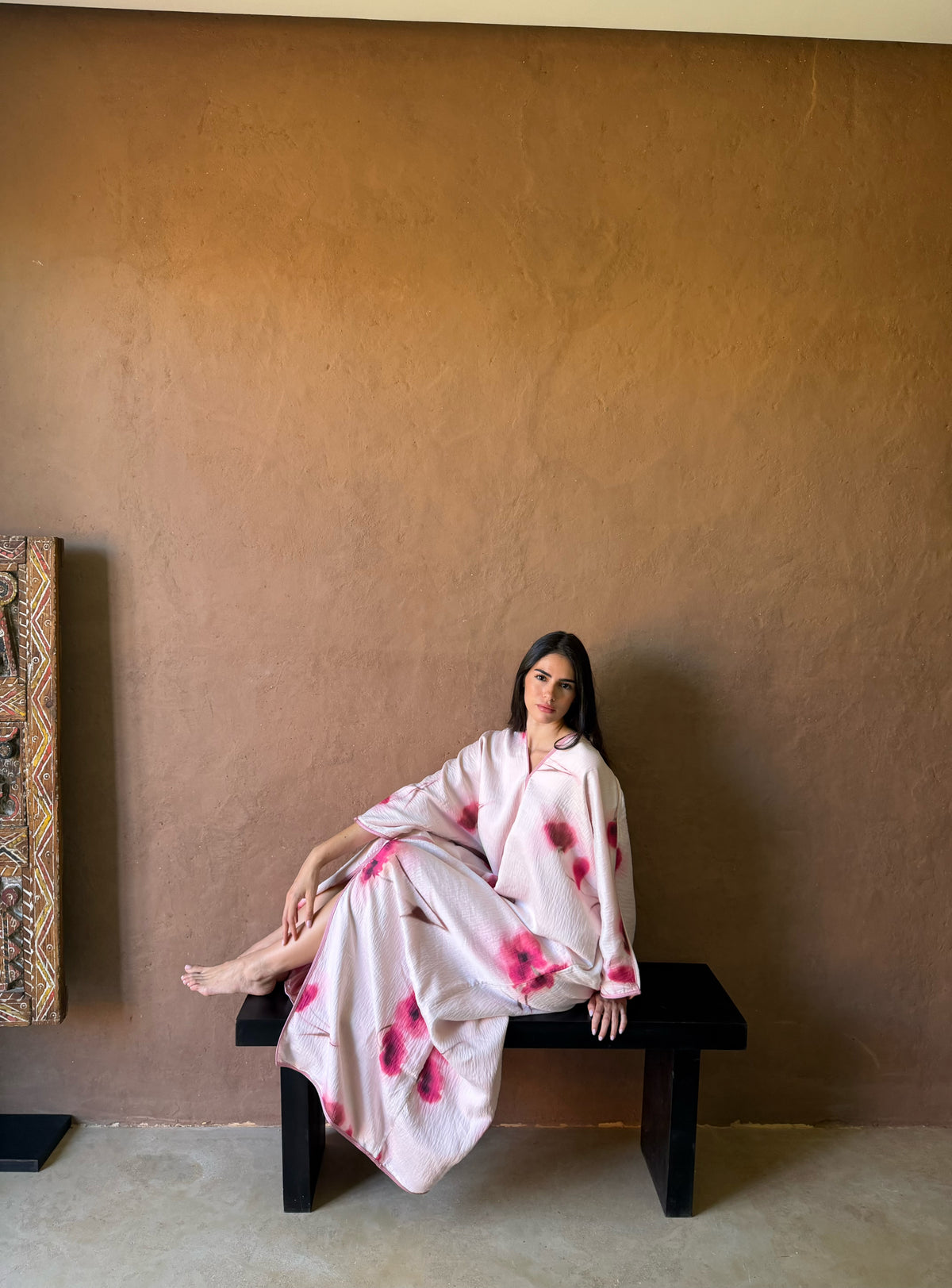 Robe Longue Rose Poudré à Fleurs Fuchsia — Silhouette assise dans un décor intérieur.