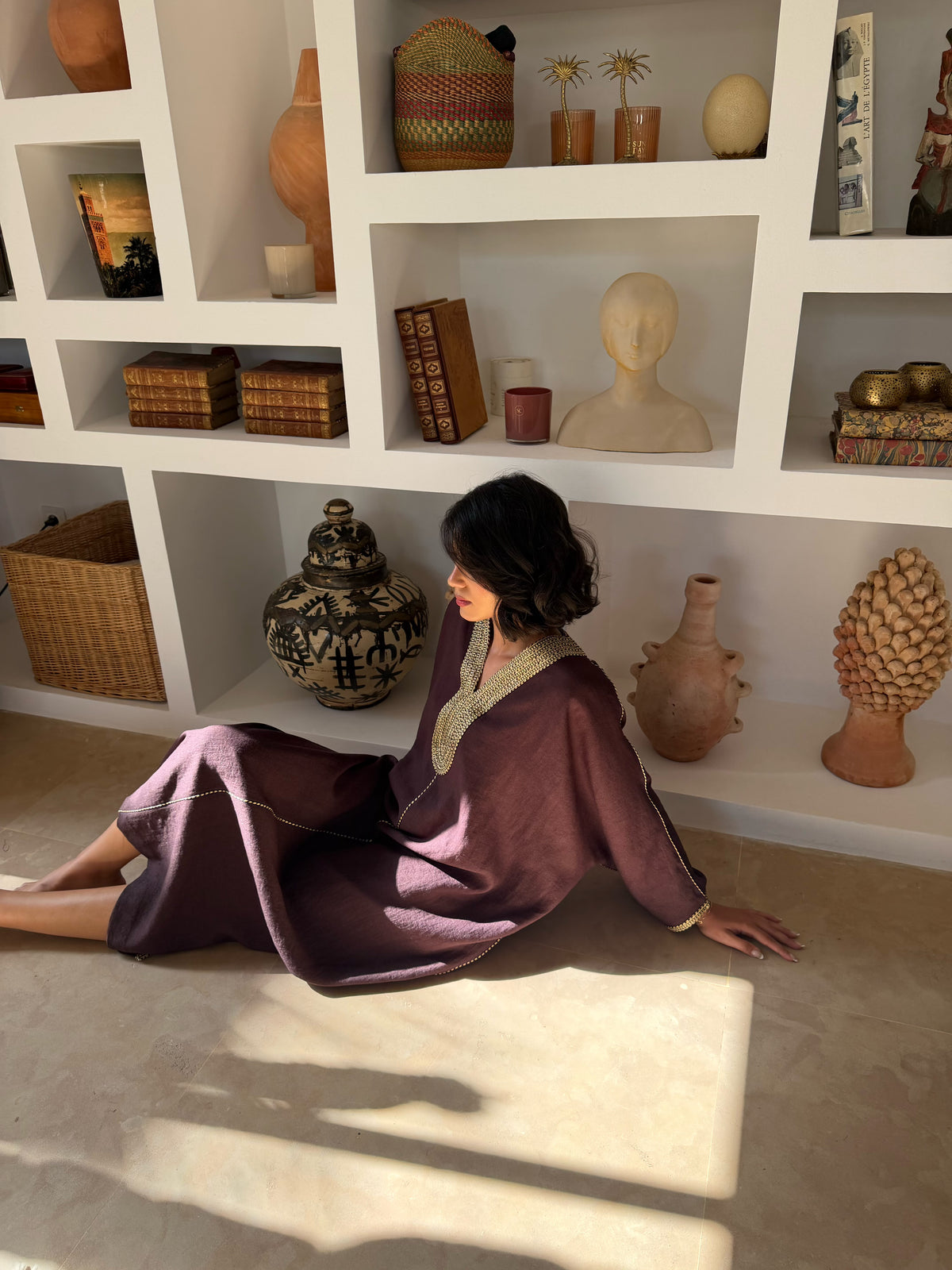 Robe Longue Prune aux Finitions Dorées — Vue assise montrant les manches et le tombé.